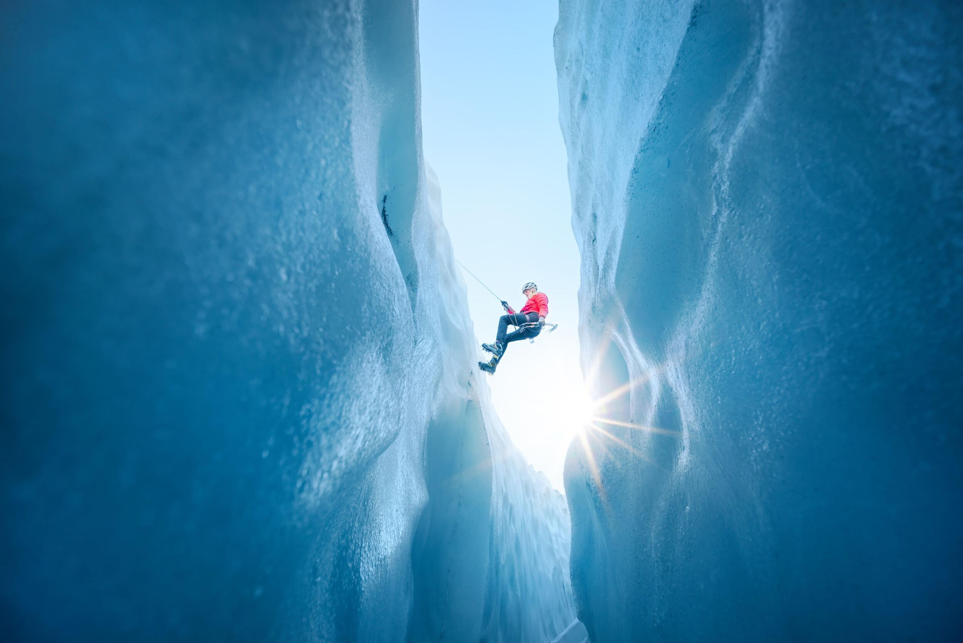 explorer climbing an ice wall in Iceland