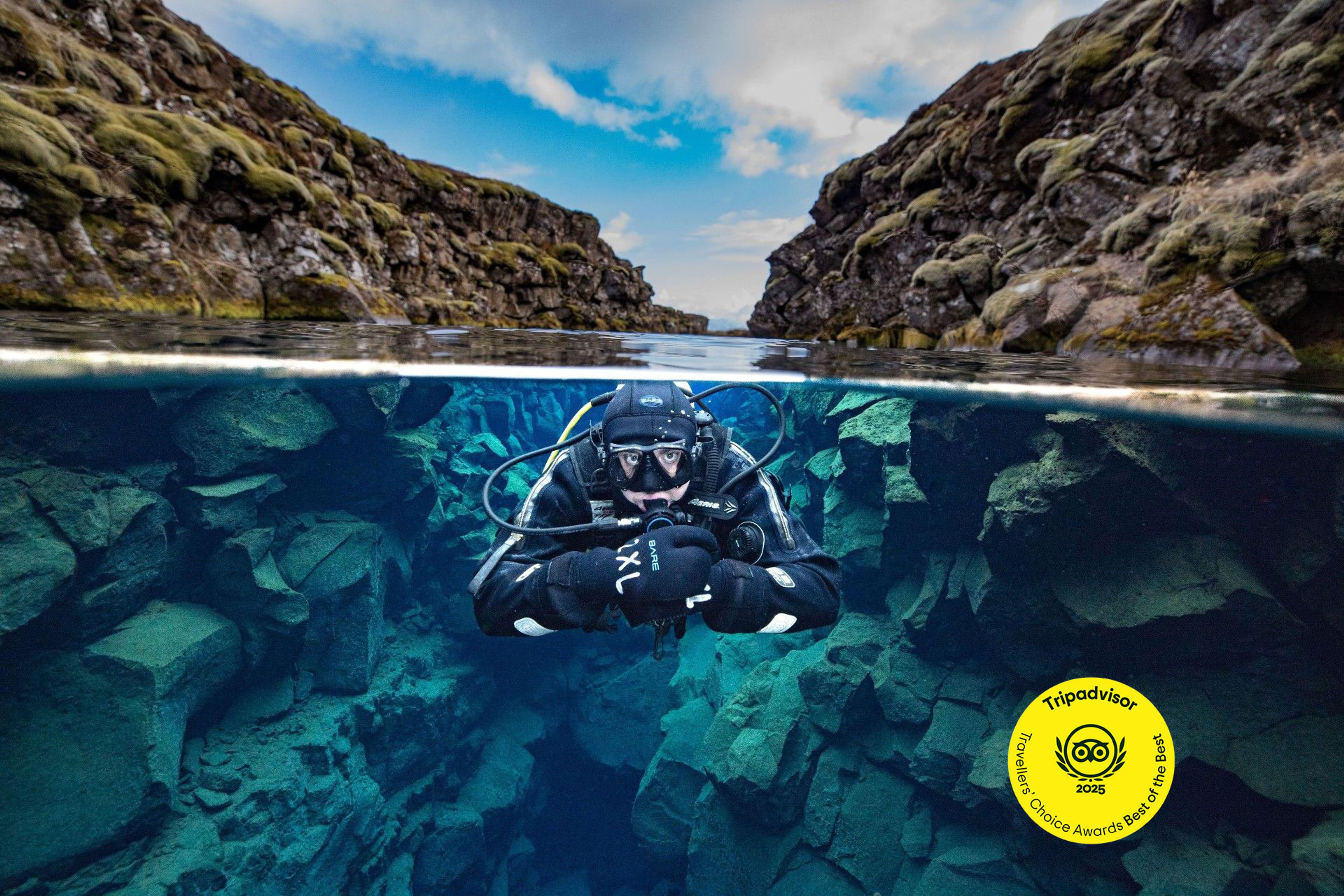 a scuba diver is swimming in a cave in the ocean .