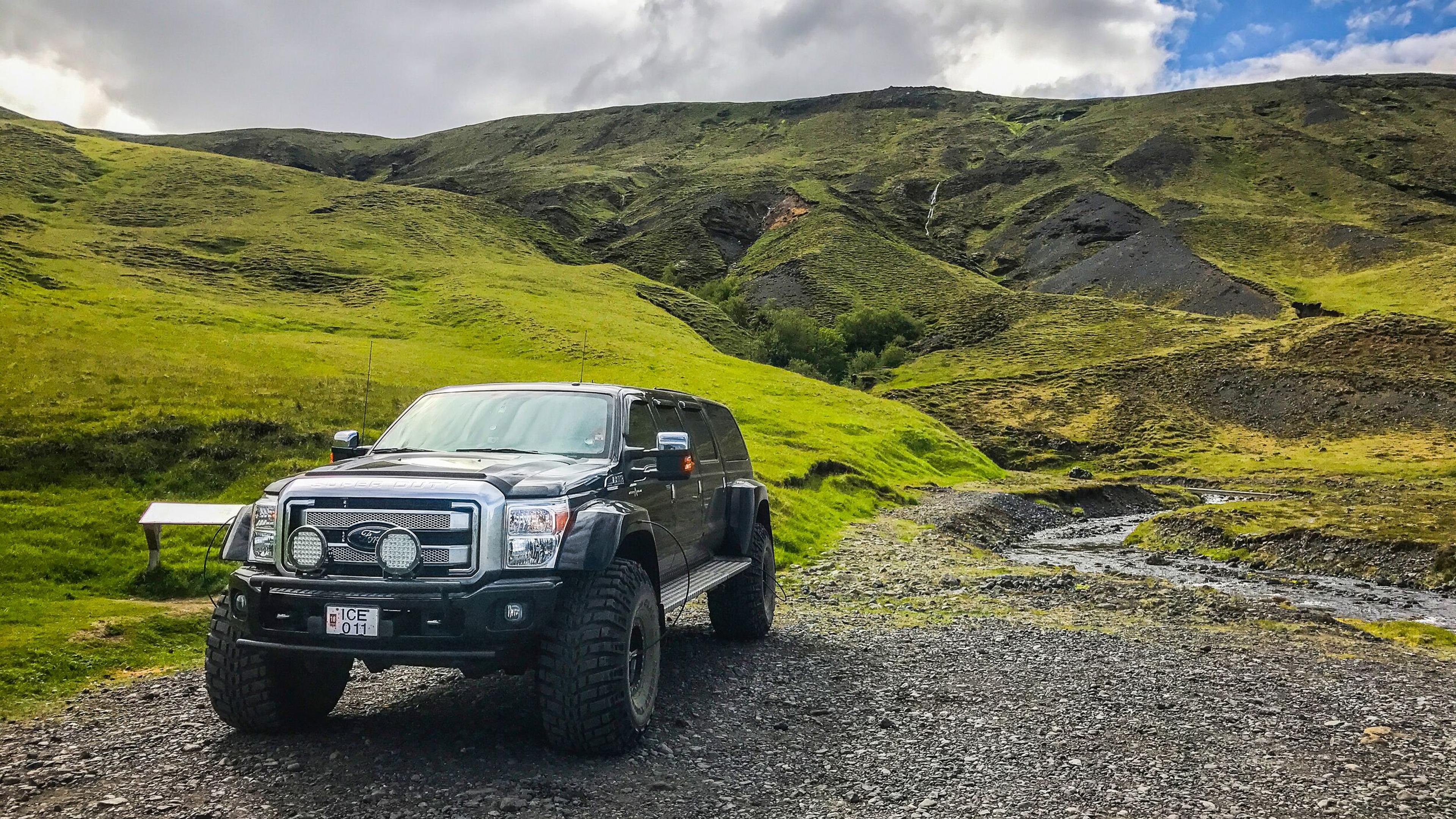 A modified super jeep driving through the icelandic highlands