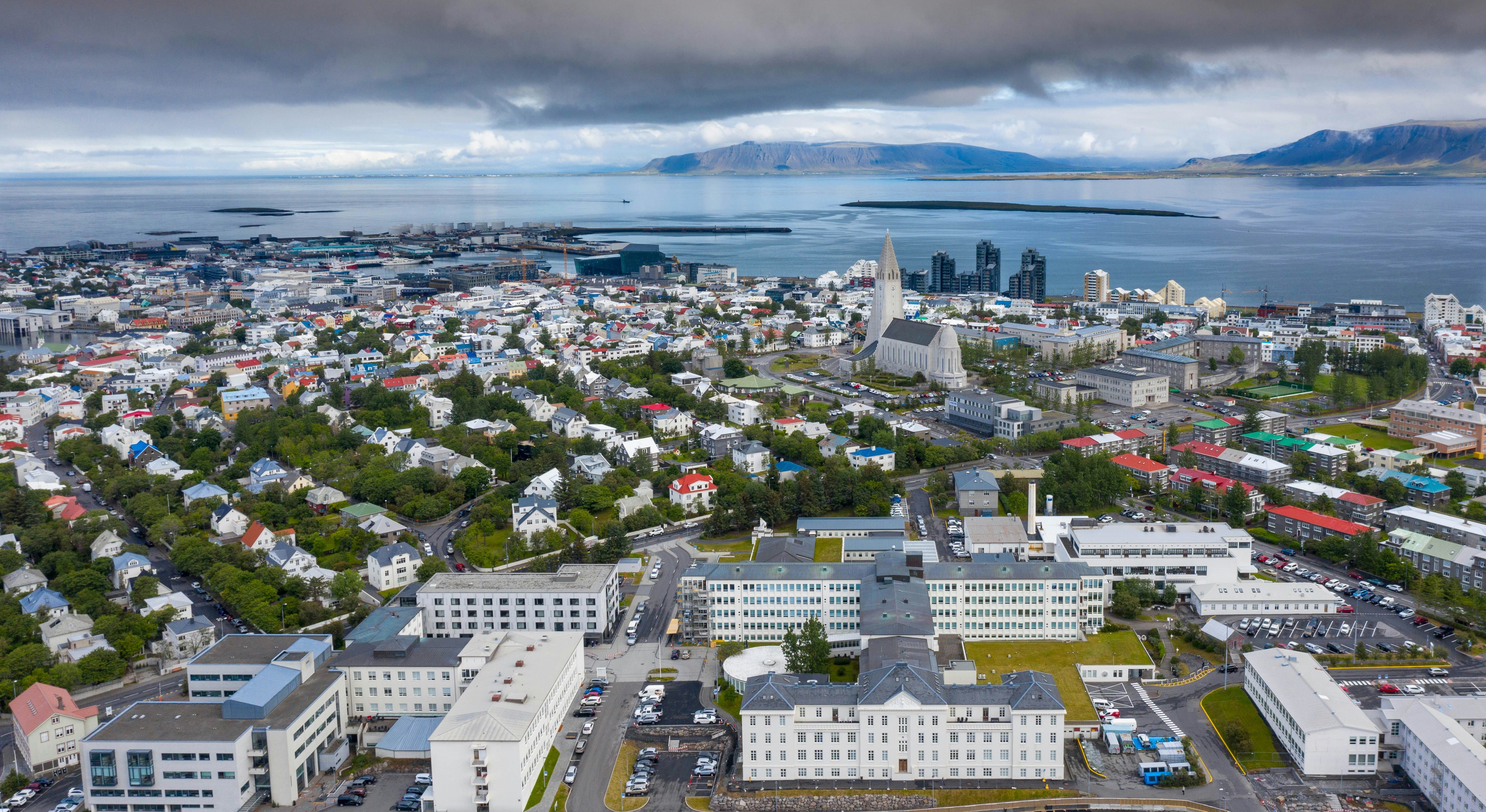 A stunning aerial view of Reykjavik, Iceland, featuring Hallgrímskirkja church, colorful houses, and the ocean, a must-visit city on any Iceland itinerary