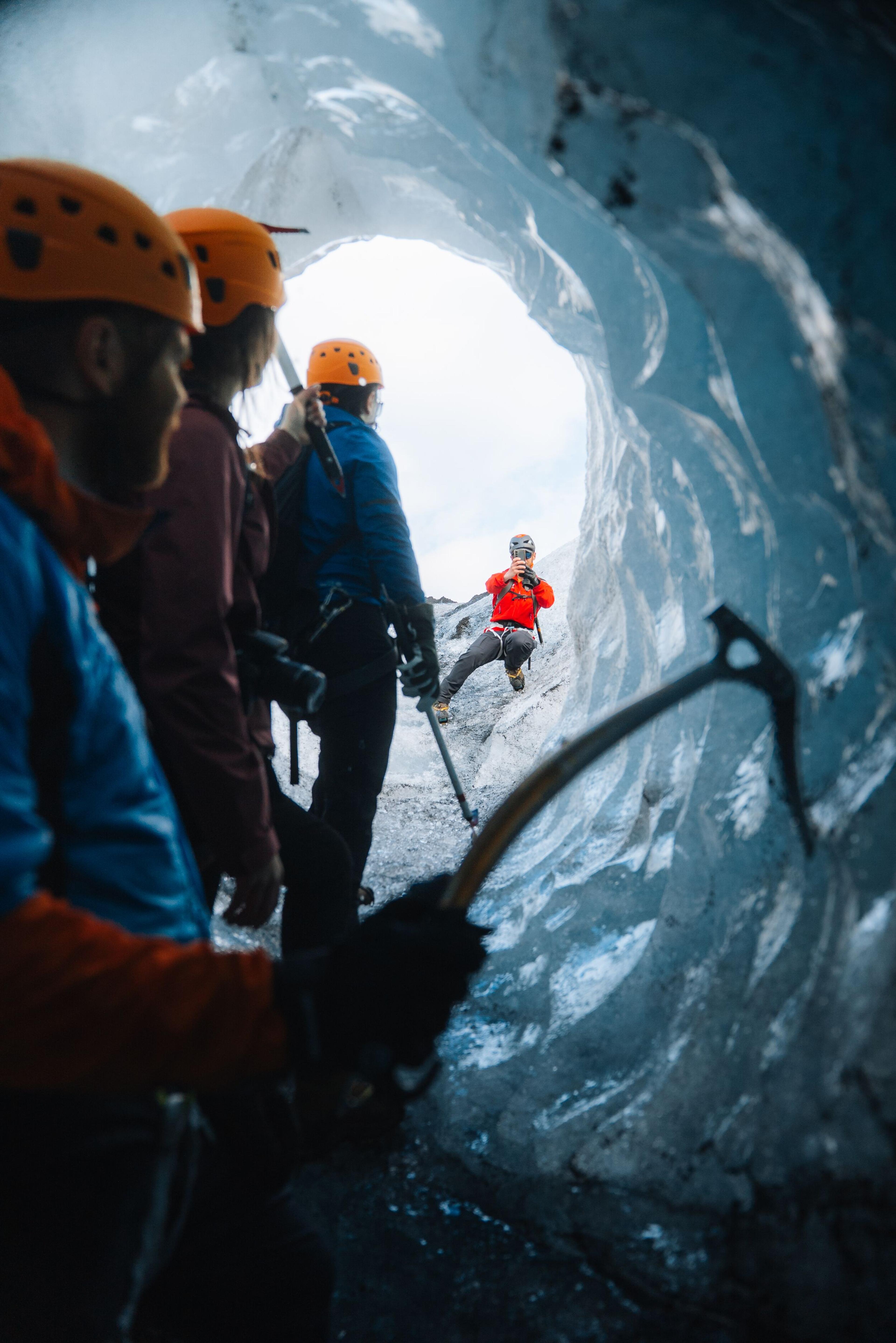 a group of people are standing inside of an ice cave .