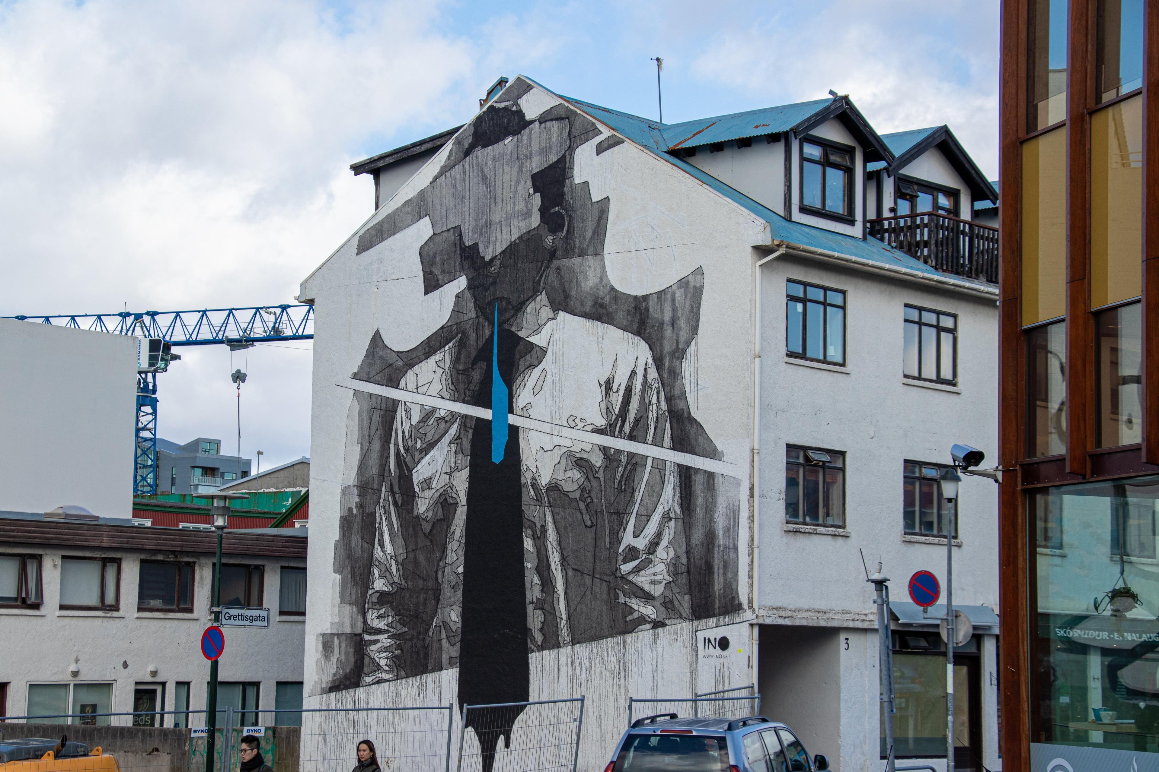 A house in Reykjavík covered in graffiti art, depicting a faceless figure donning a tie.