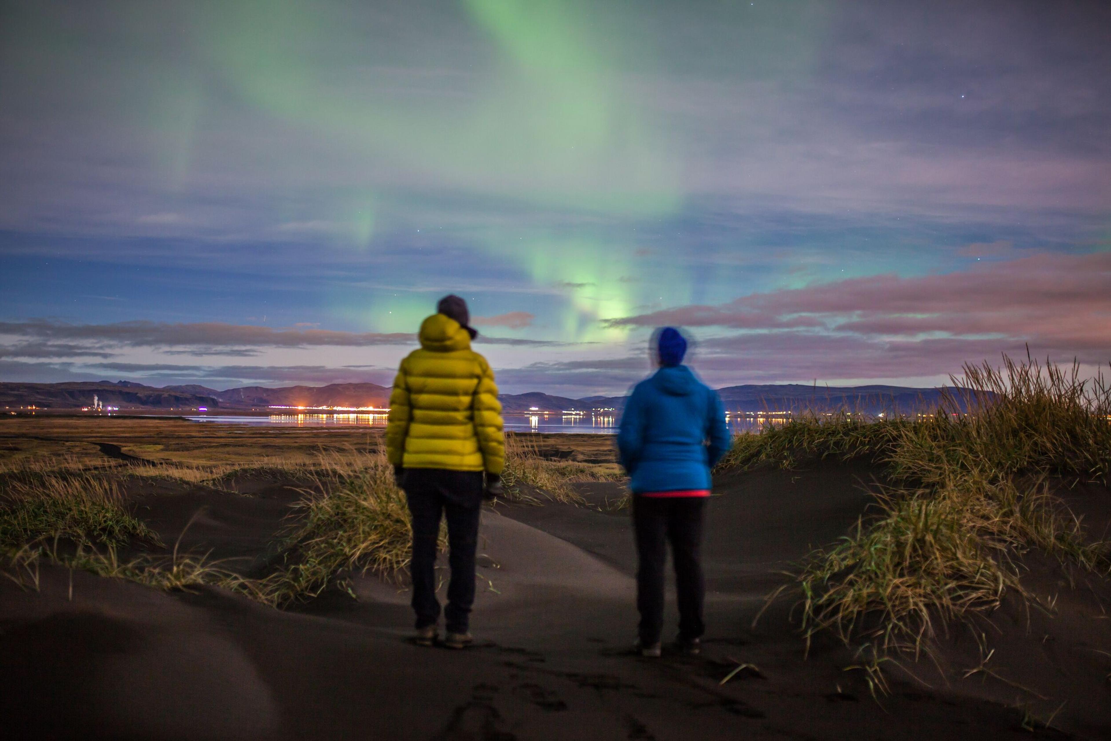 Two people looking at nothern lights in the sky in Iceland.