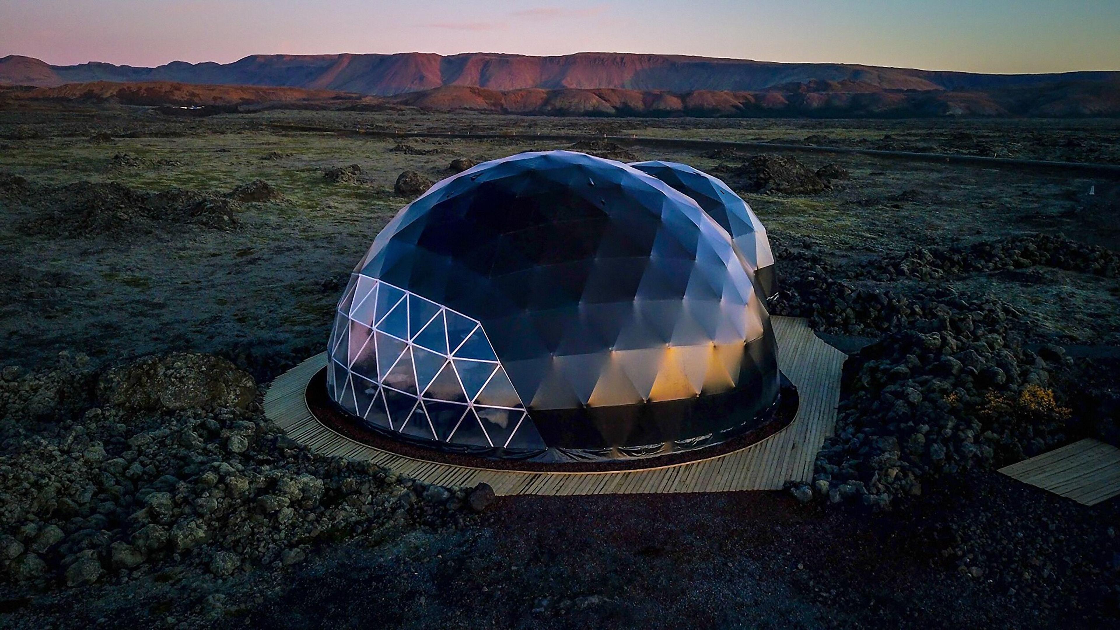  Large geodesic dome at Aurora Base Camp, Iceland, set against a volcanic landscape, ideal for northern lights viewing.