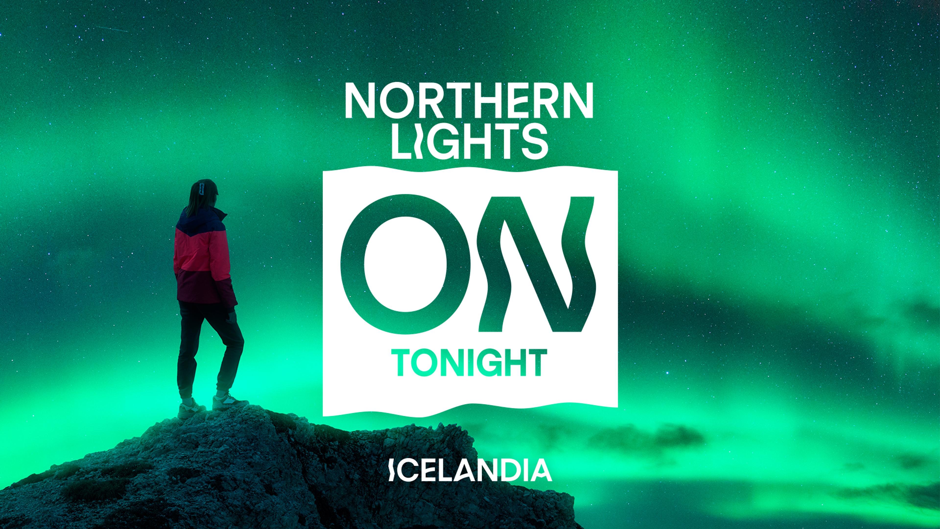 A person stands on a rock under green Northern Lights, with text "NORTHERN LIGHTS ON TONIGHT ICELANDIA".