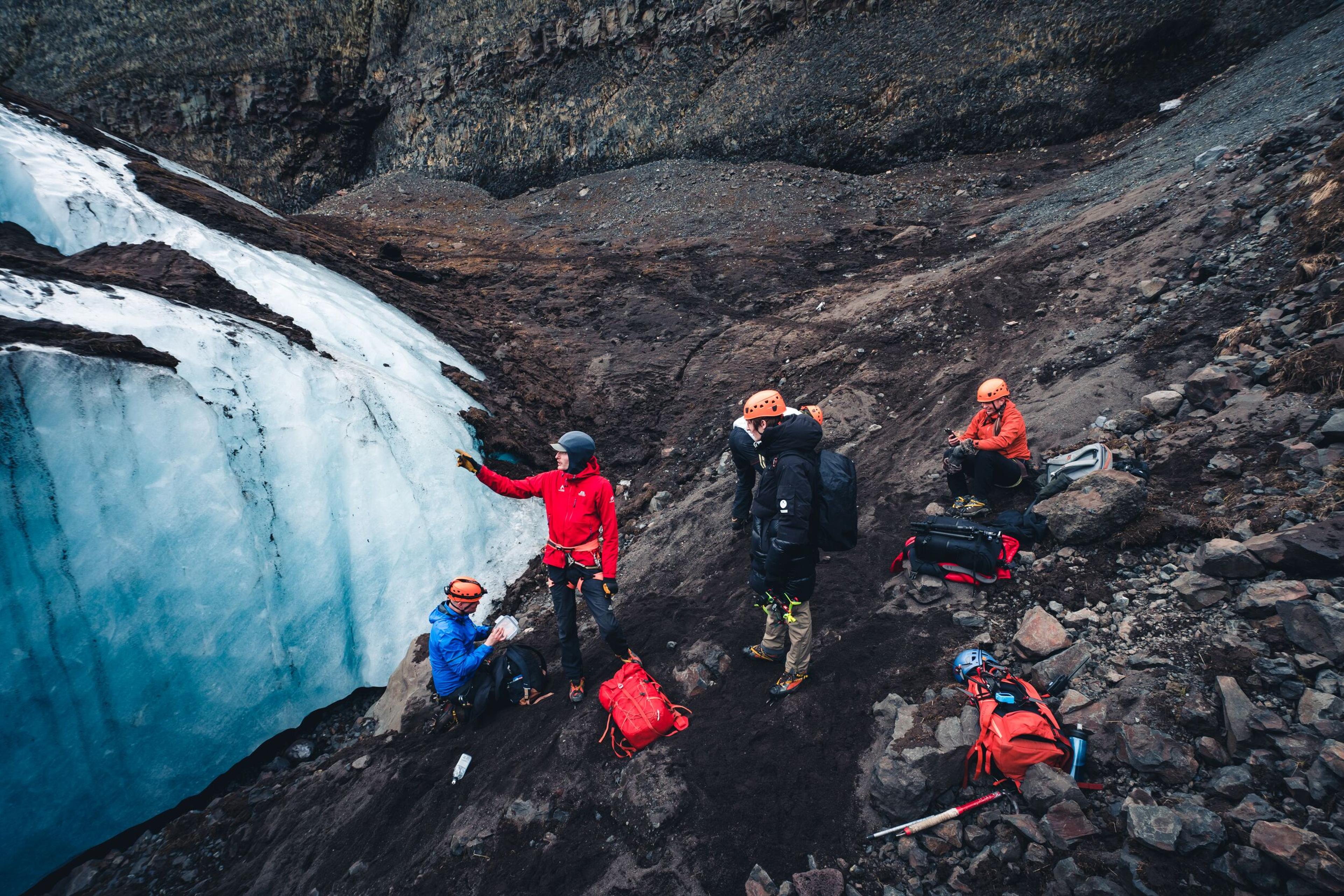 A guide and a group of explorers by a glaicer outlet in Iceland.