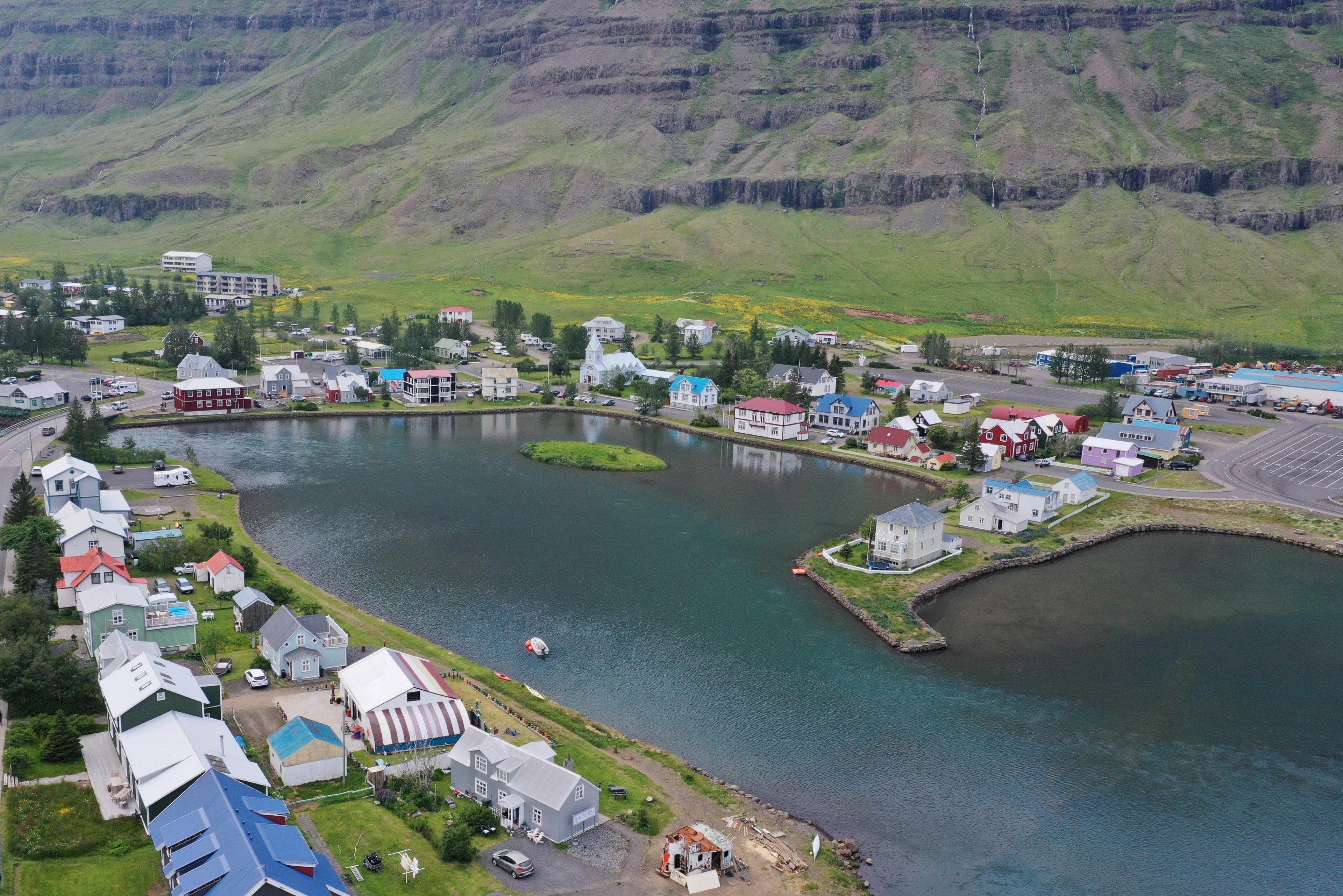 Overhead view of a quaint fjord-side town, dotted with vibrant, colorful houses nestled amidst the natural landscape