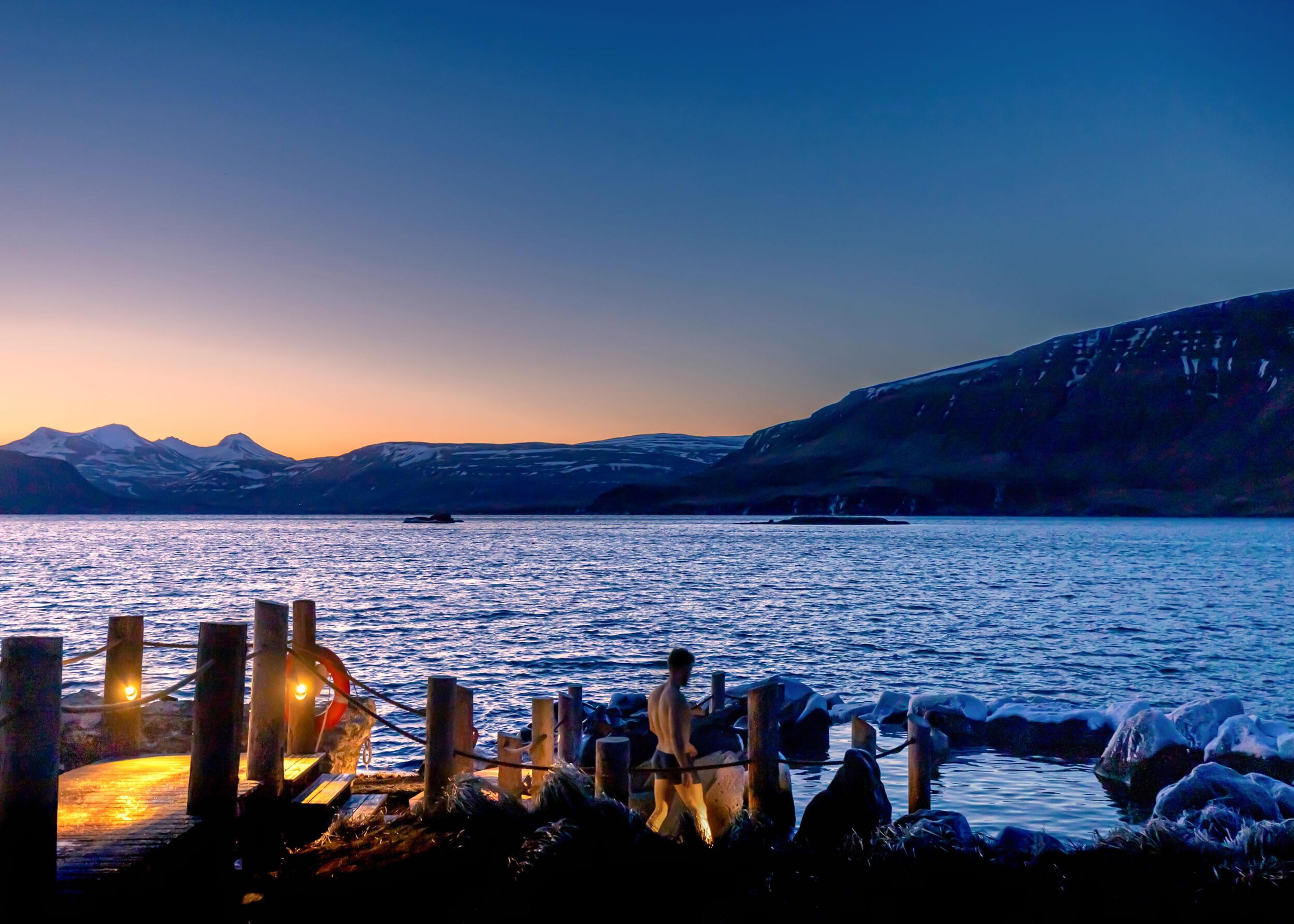 Sunrise hues over the serene Hvammsvik hot springs.