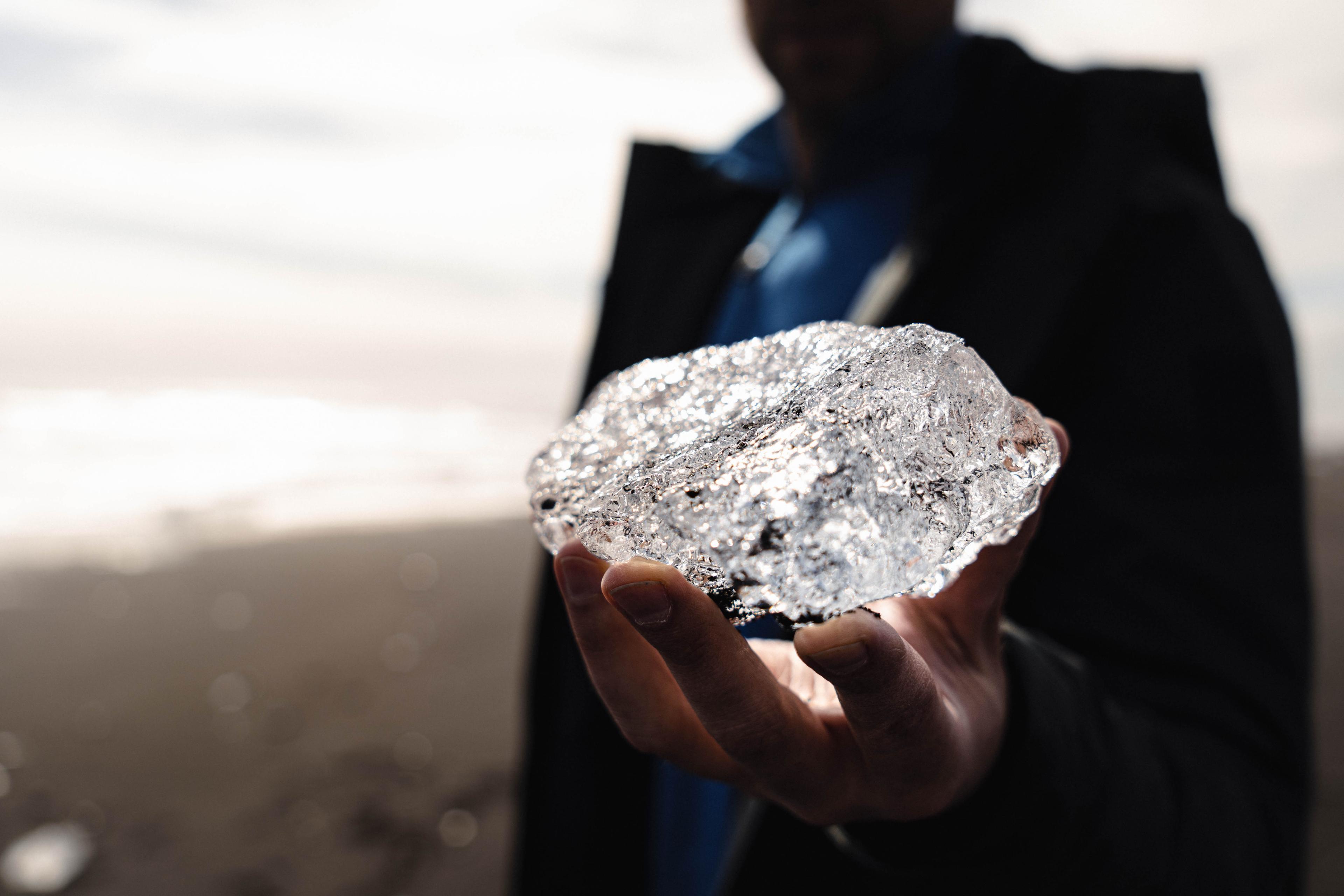 A person holding a piece of ice in the Diamond Beach