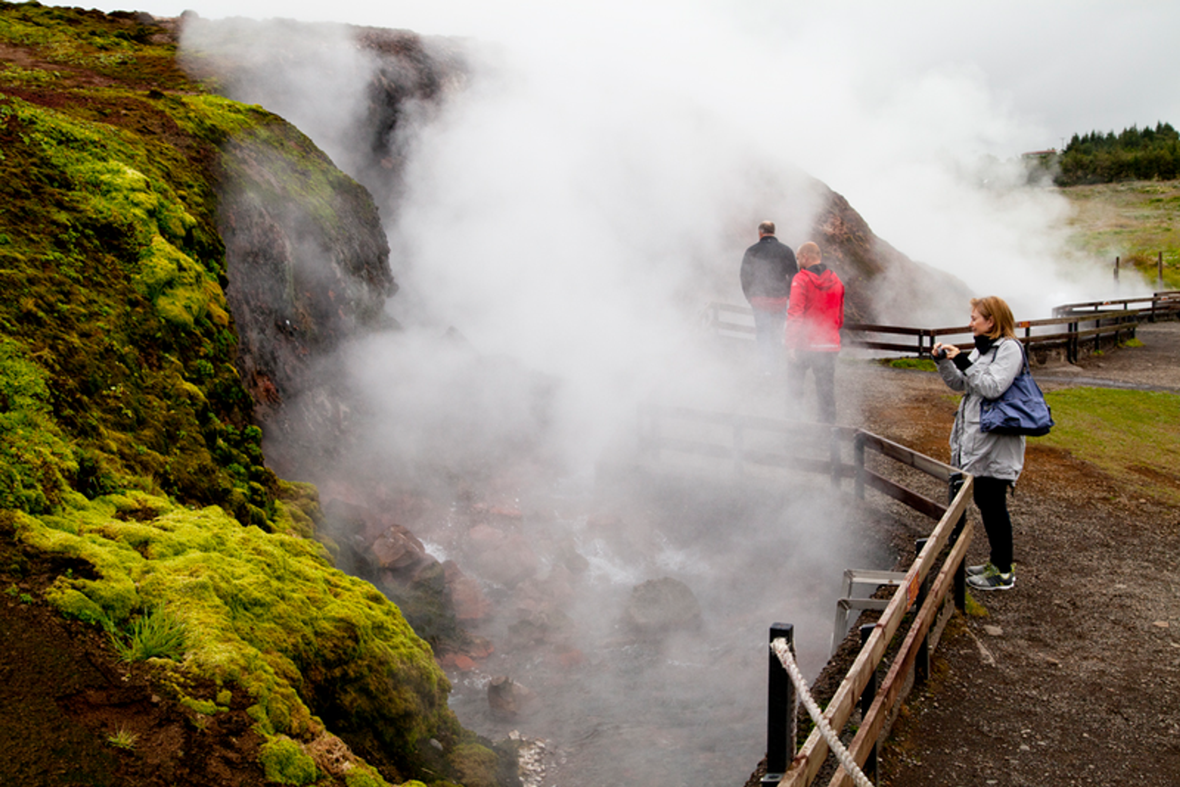 group of people taking a picture of a hot spring.
