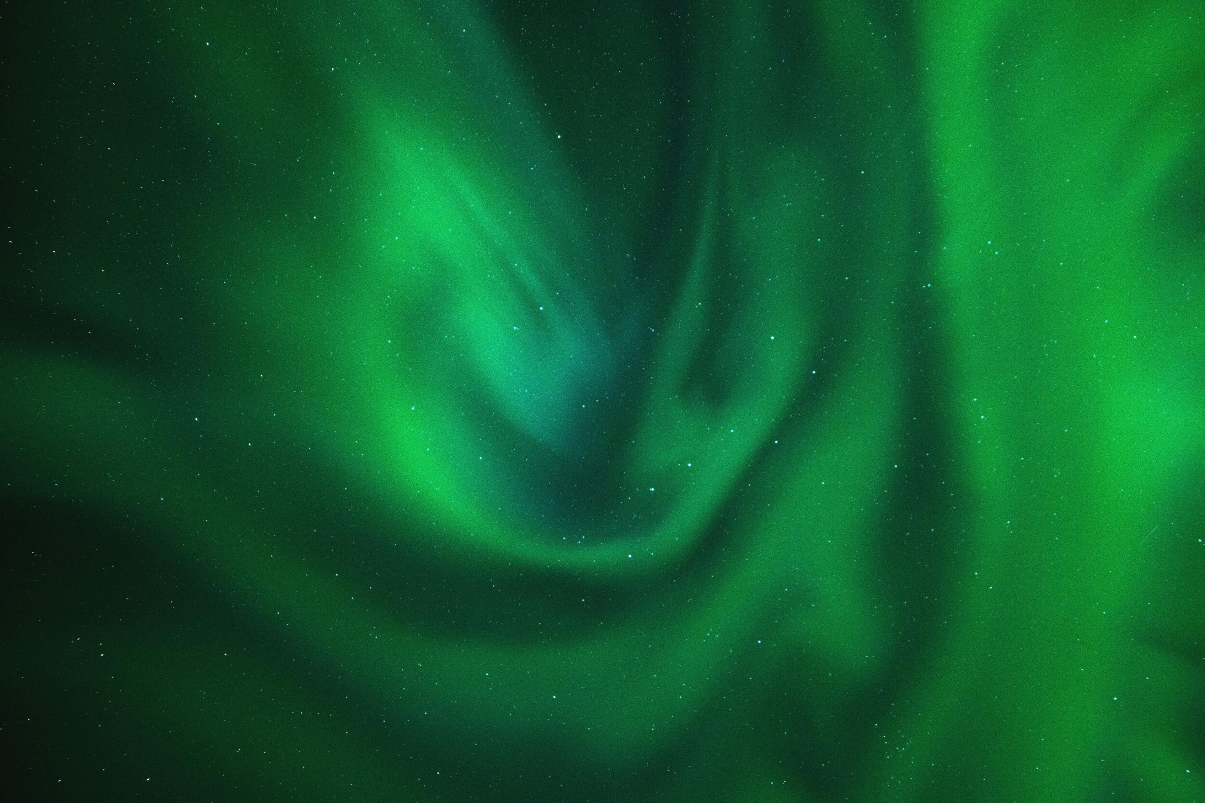 A mesmerizing view of the aurora borealis illuminating the night sky with swirling green and blue light patterns.