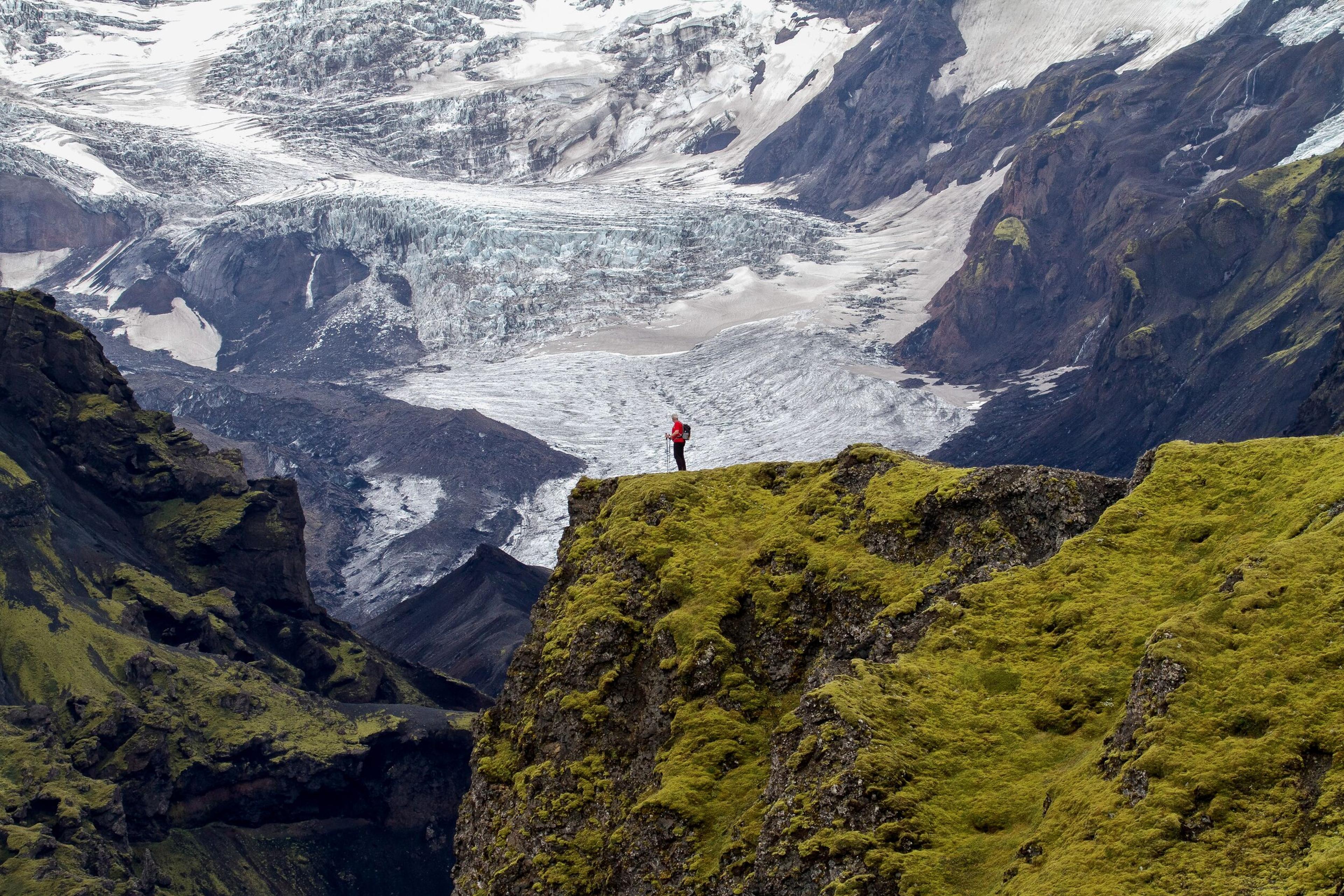 Hiker embarking on the challenging Fimmvörðuháls Trail, showcasing Iceland's rugged highlands