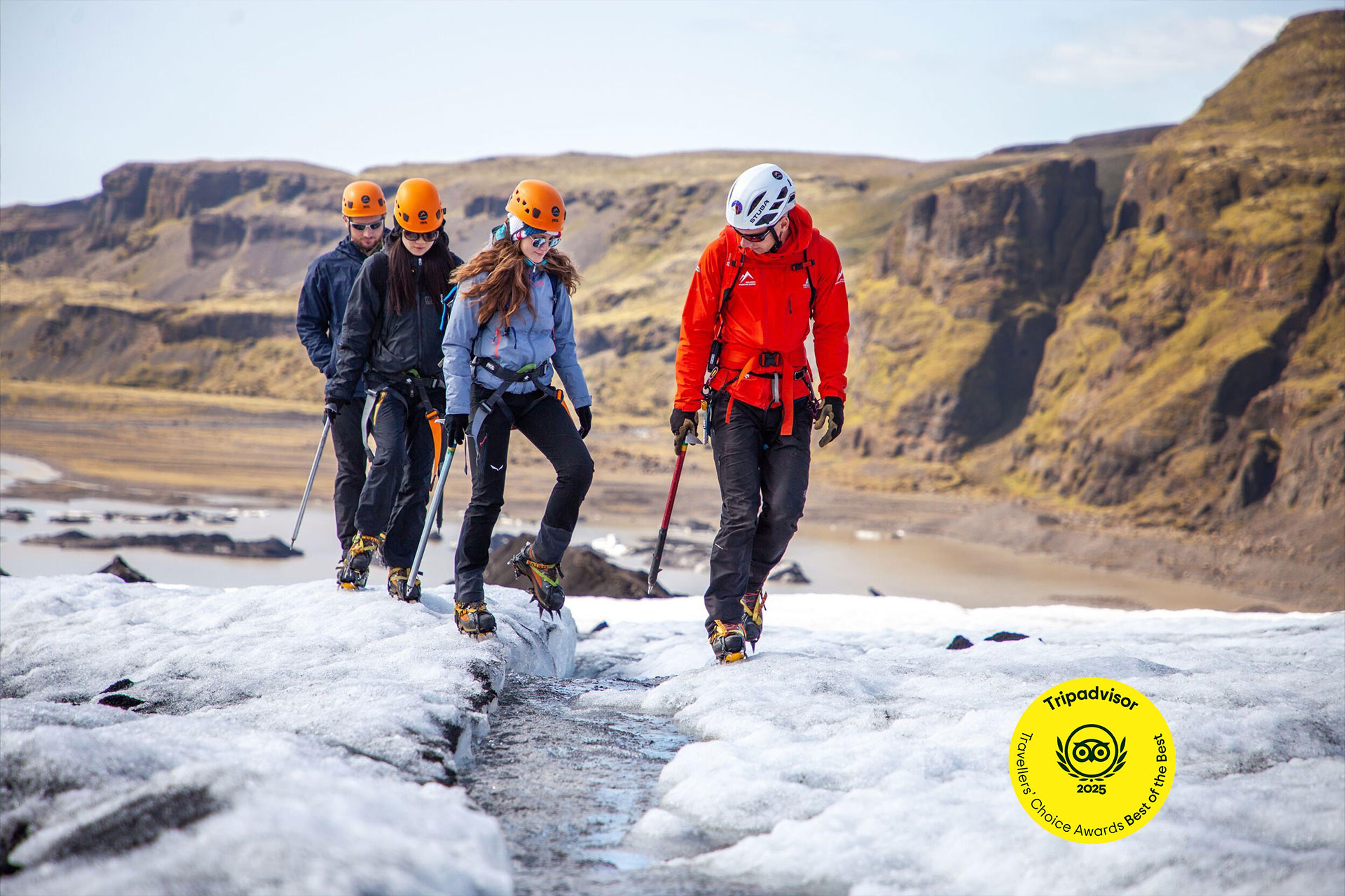 a group of people are walking on top of a glacier .