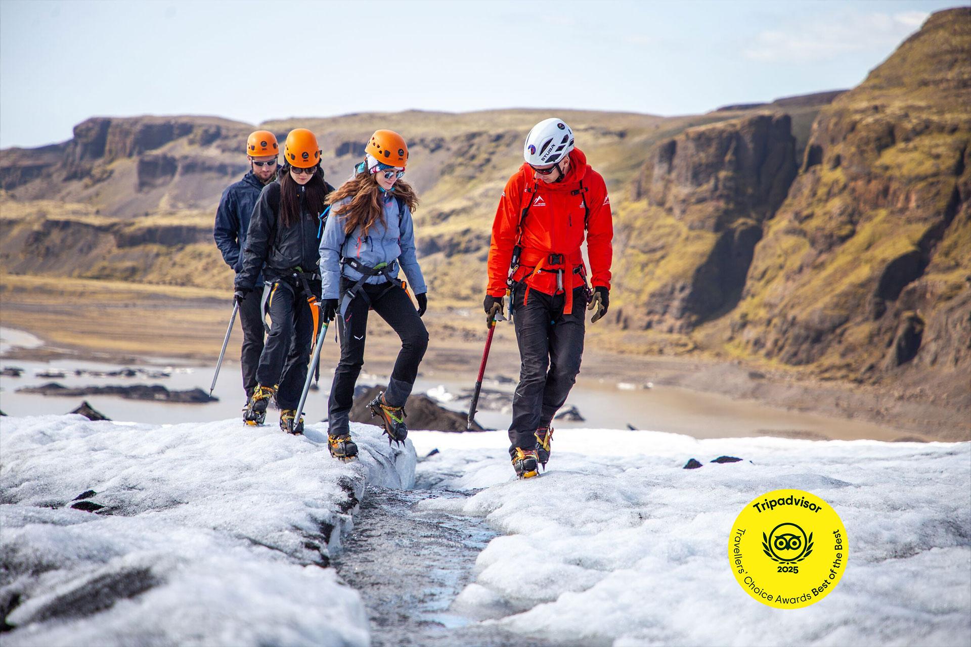 a group of people are walking on top of a glacier .