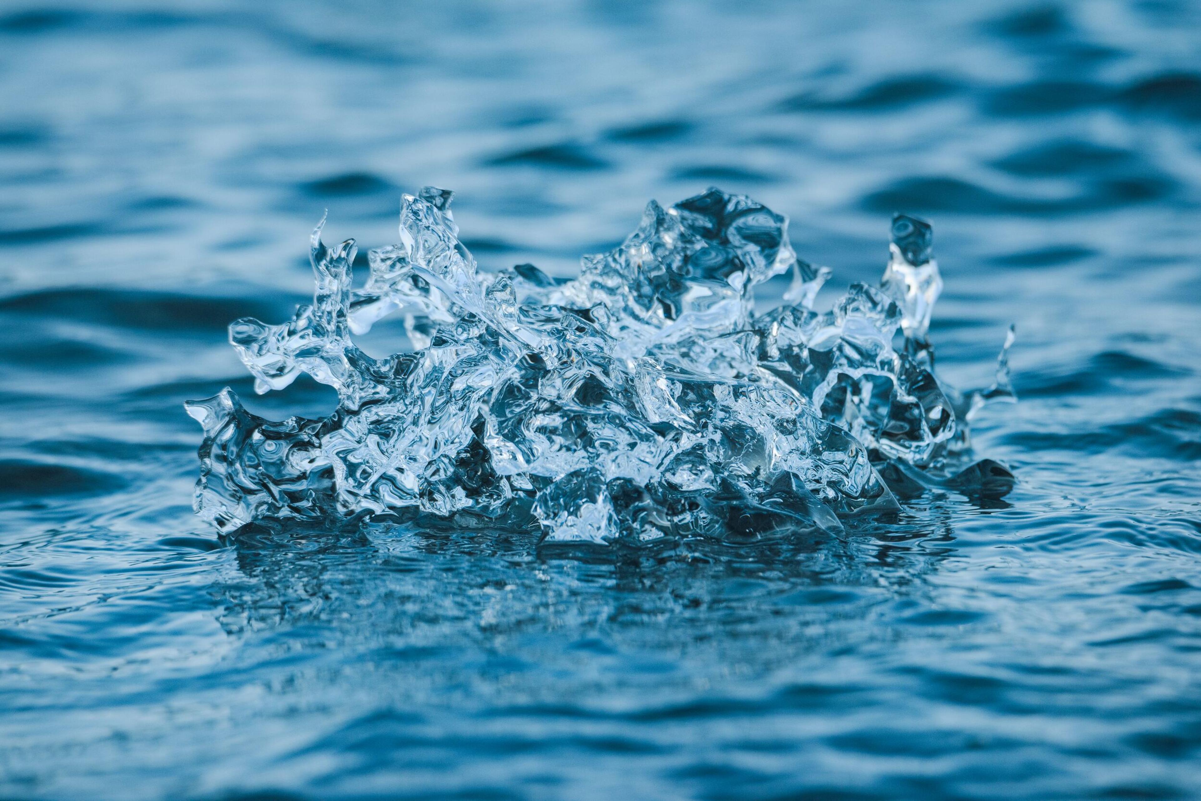 Clear water splashing up from a blue surface.