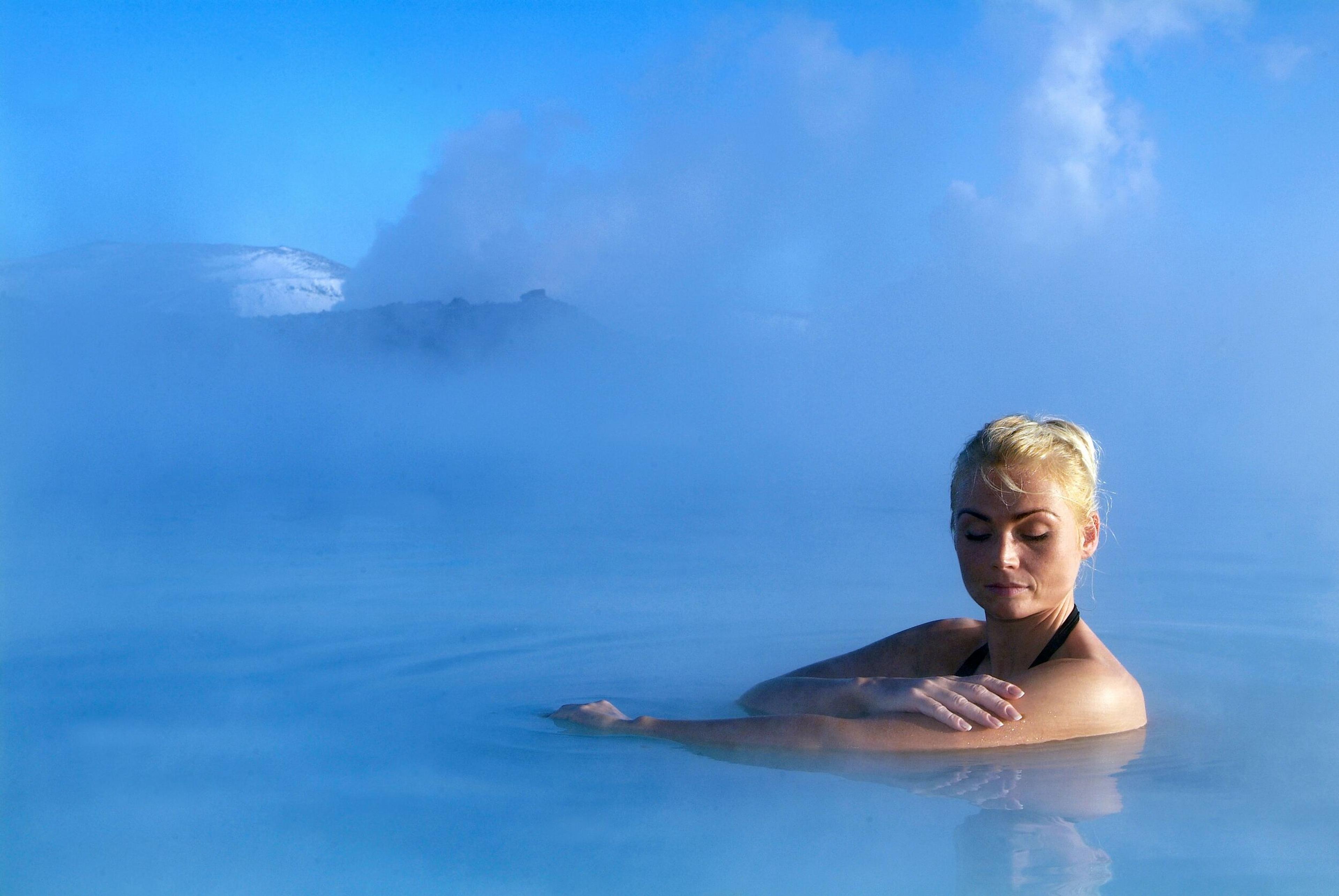 A woman bathing in the geothermal waters of Blue Lagoon, Iceland.