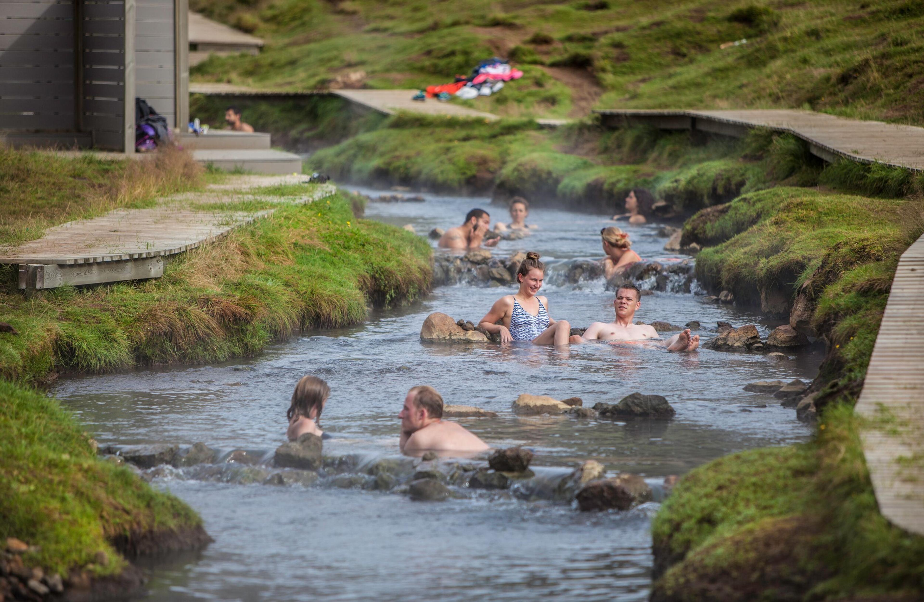 a group of people are swimming in a stream of hot water .