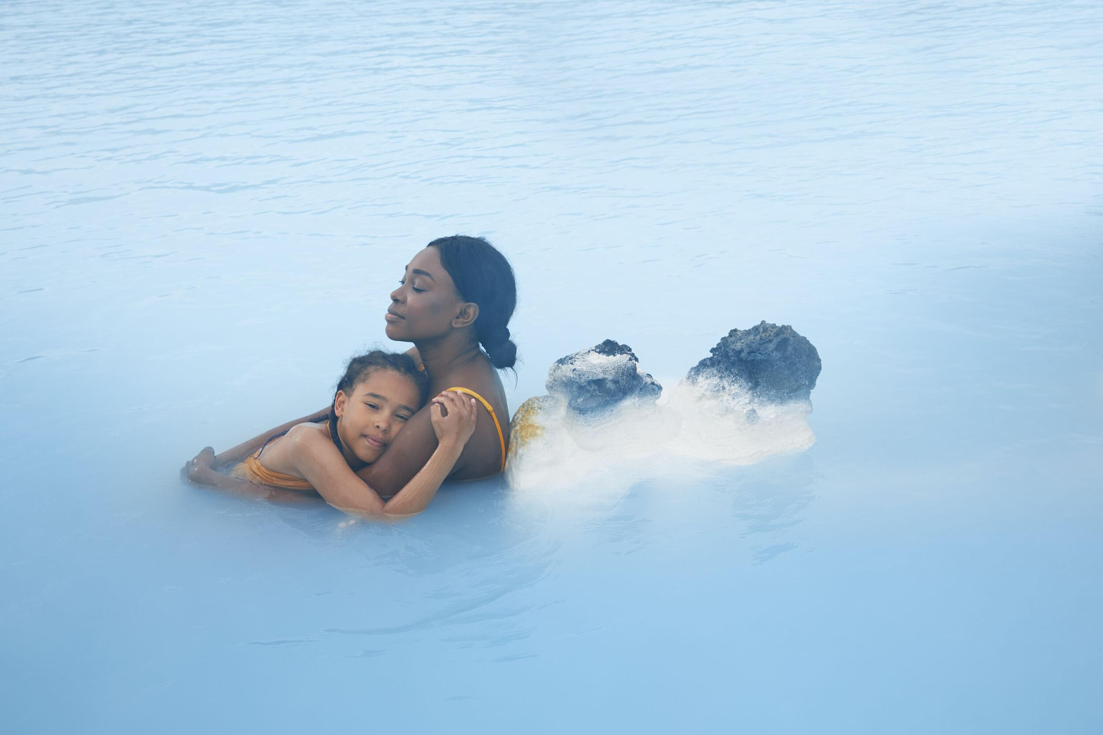 A woman and a child relaxing in the silica water at blue lagoon in Iceland.