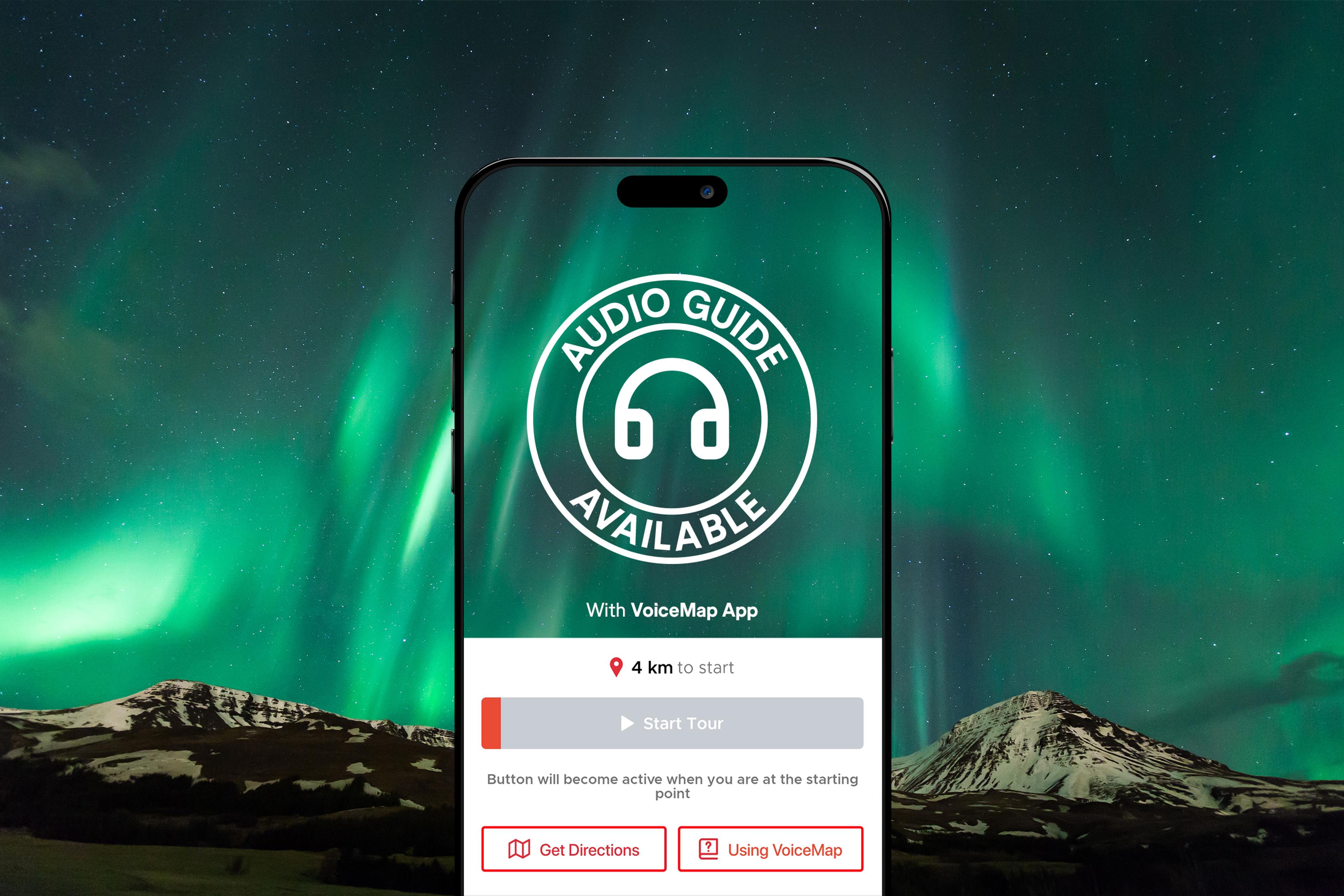 A smartphone screen displaying a VoiceMap app interface is superimposed over a breathtaking view of the Northern Lights, with a circular "Audio Guide Available" icon in the center.