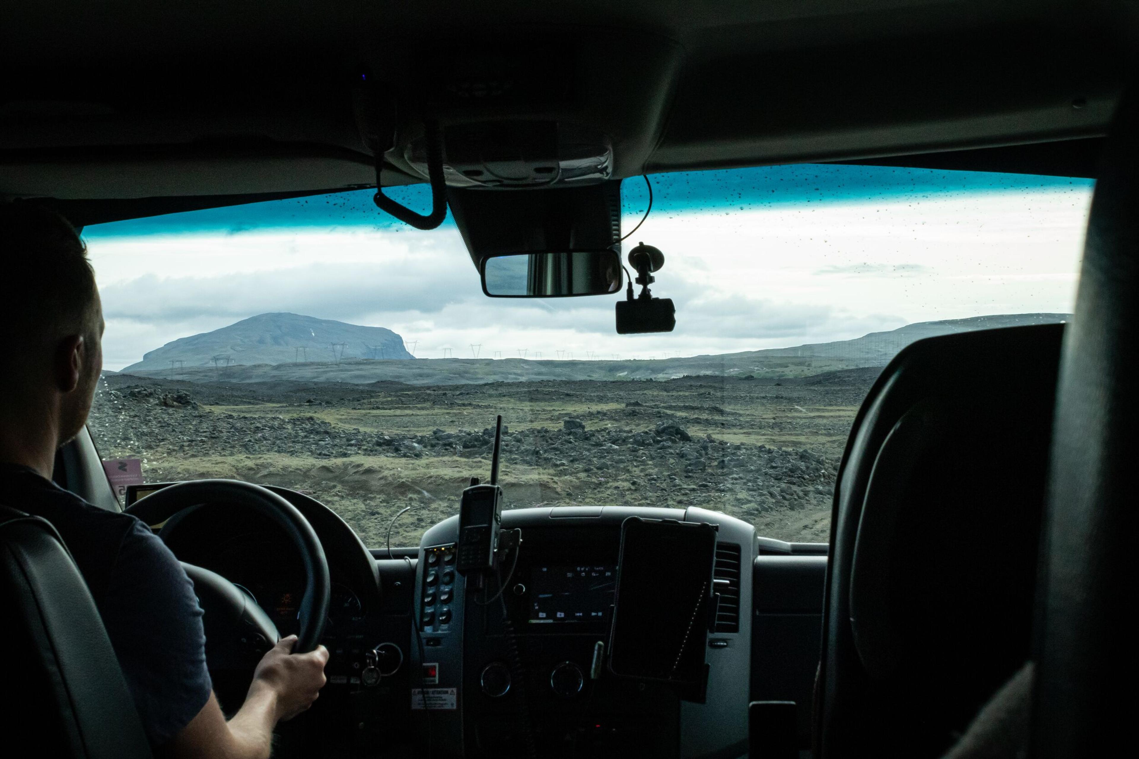 Interior view of a Landmannalaugar superjeep with driver navigating the Iceland Highlands.