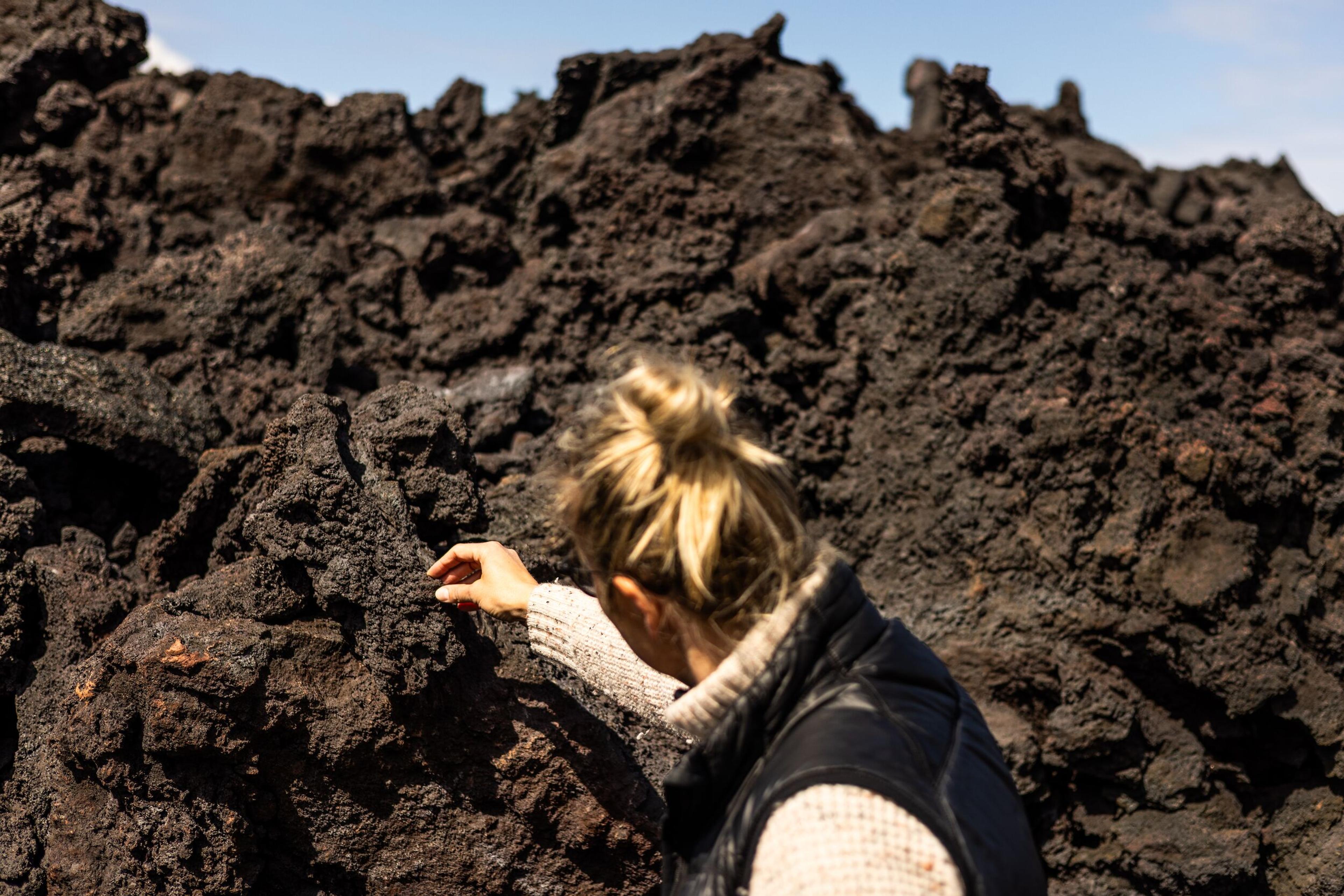 a woman is standing on top of a pile of rocks .