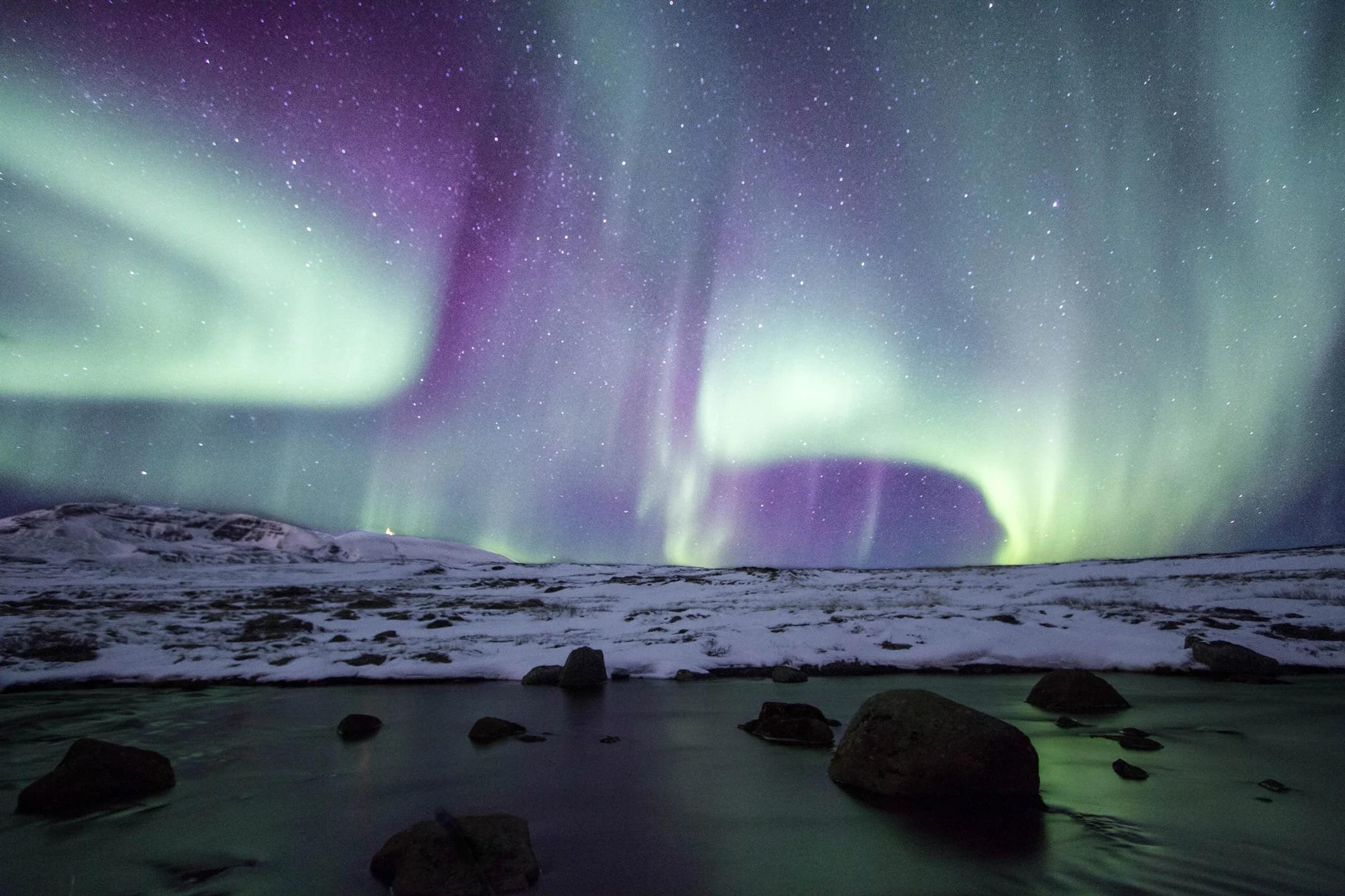 The green glow of the aurora borealis lighting up the night sky over Iceland.