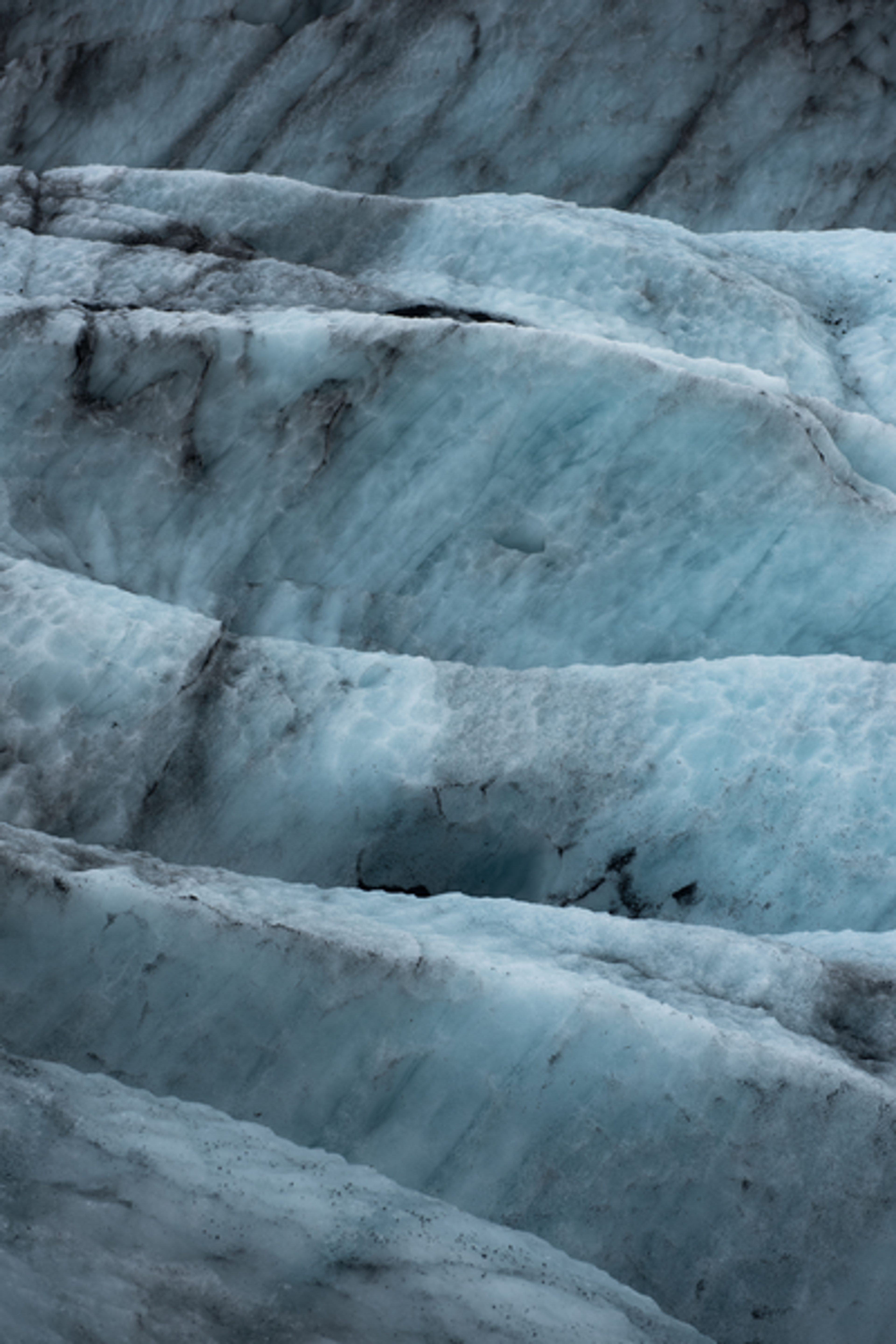 Close-up of the icy blue layers and crevices of Mýrdalsjökull glacier, showcasing its textured surface.