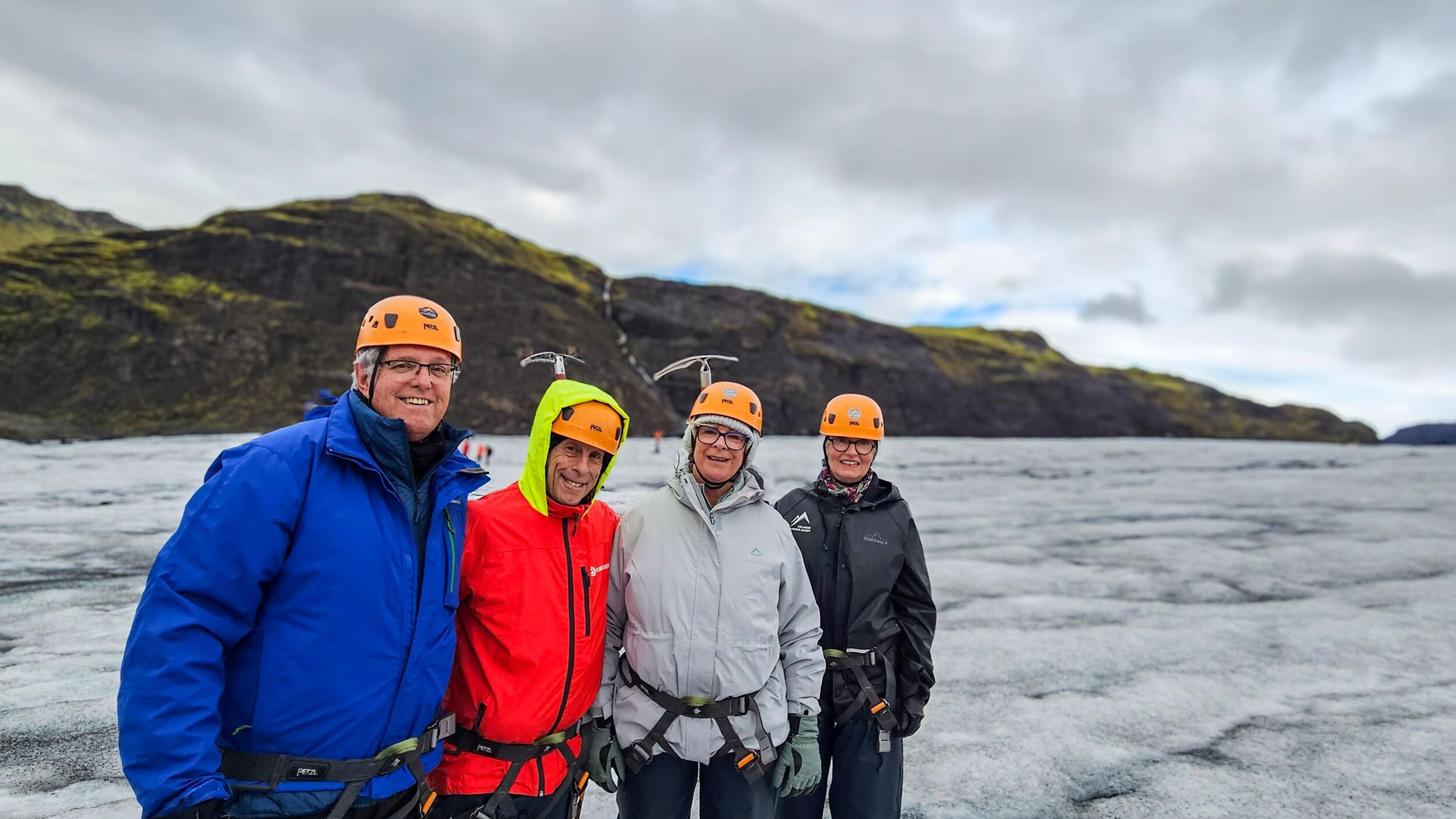 a group of people are posing for a picture on a glacier .