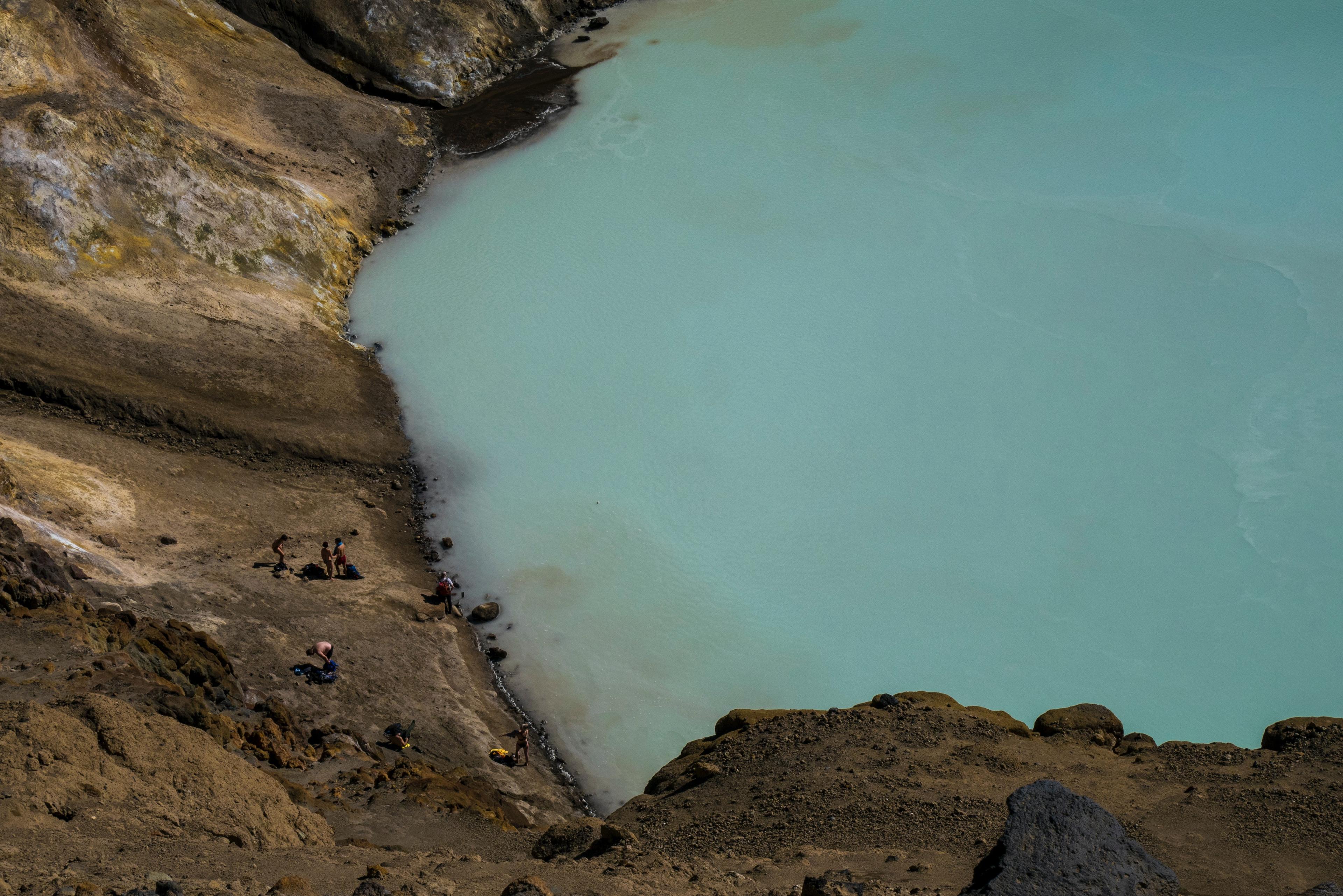 Close up of the Caldera lake in Askja. Group of people by the shore