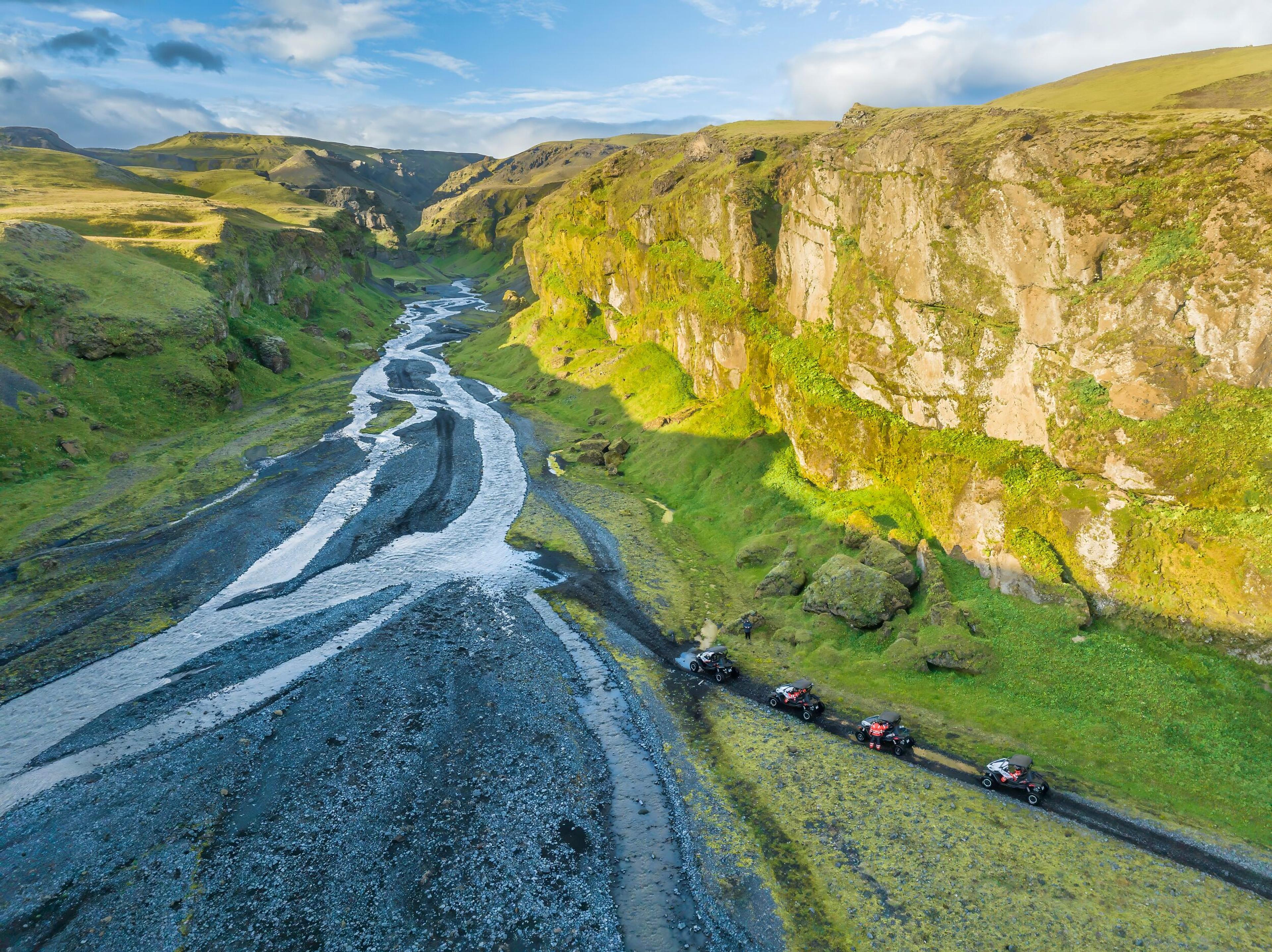 A convoy of buggies fording a shallow river during an adventurous buggy tour in the scenic landscapes of Iceland.