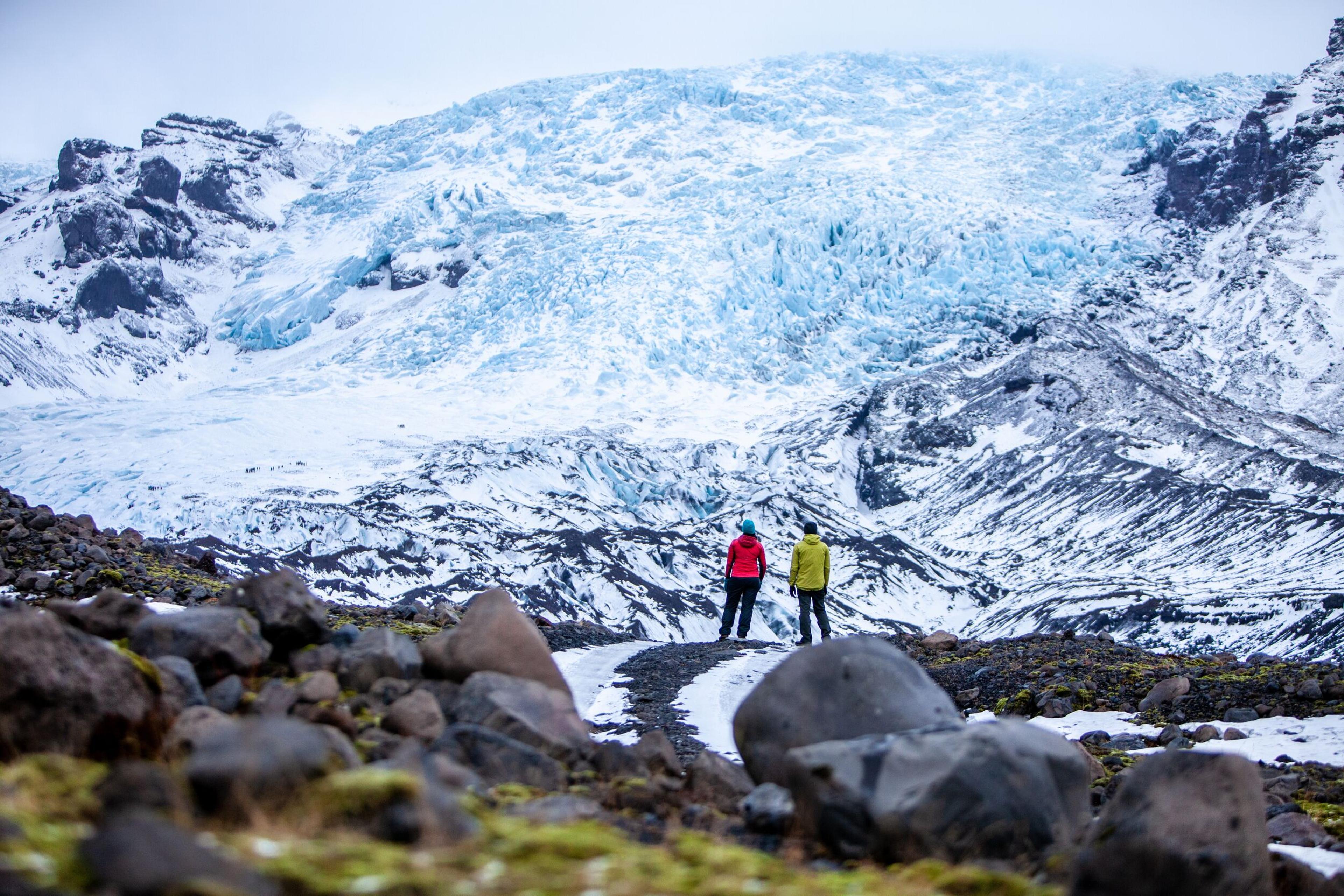 Two explorers looking at the Öræfajökull Glacier in the Vatnajökull area, Iceland.