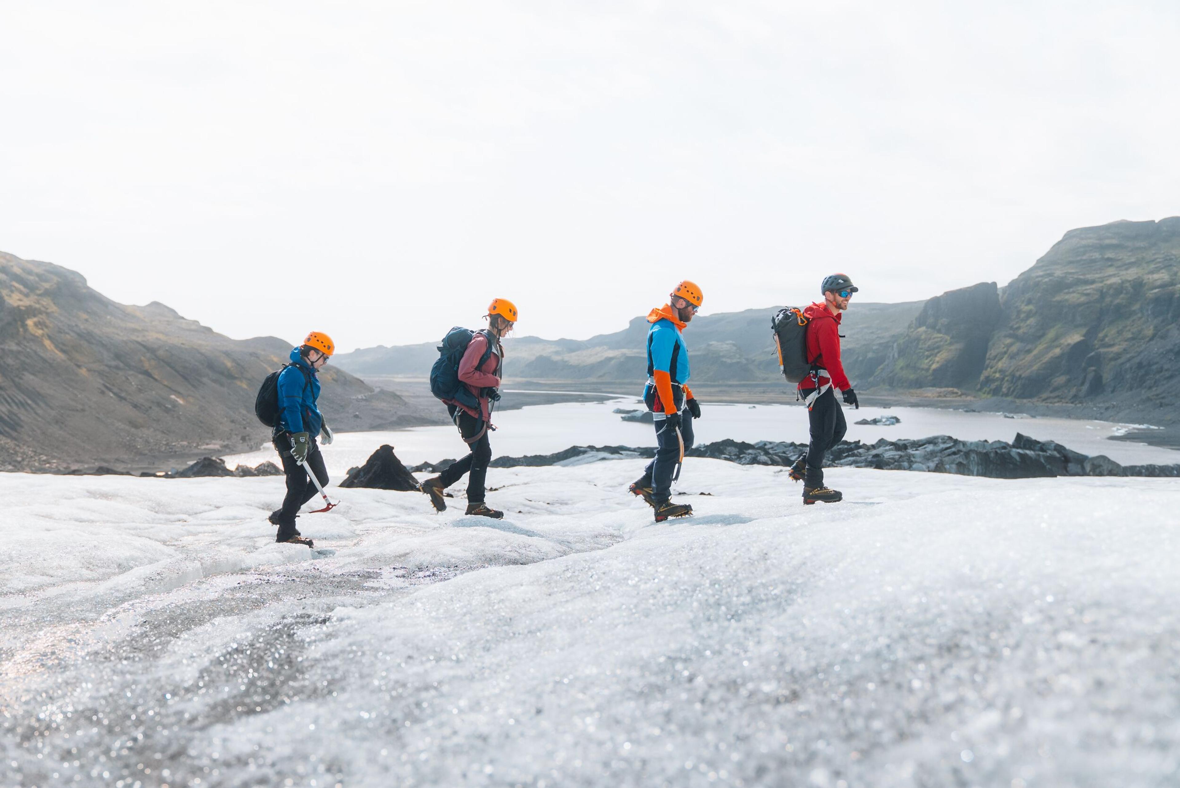 a group of people are walking on a glacier .