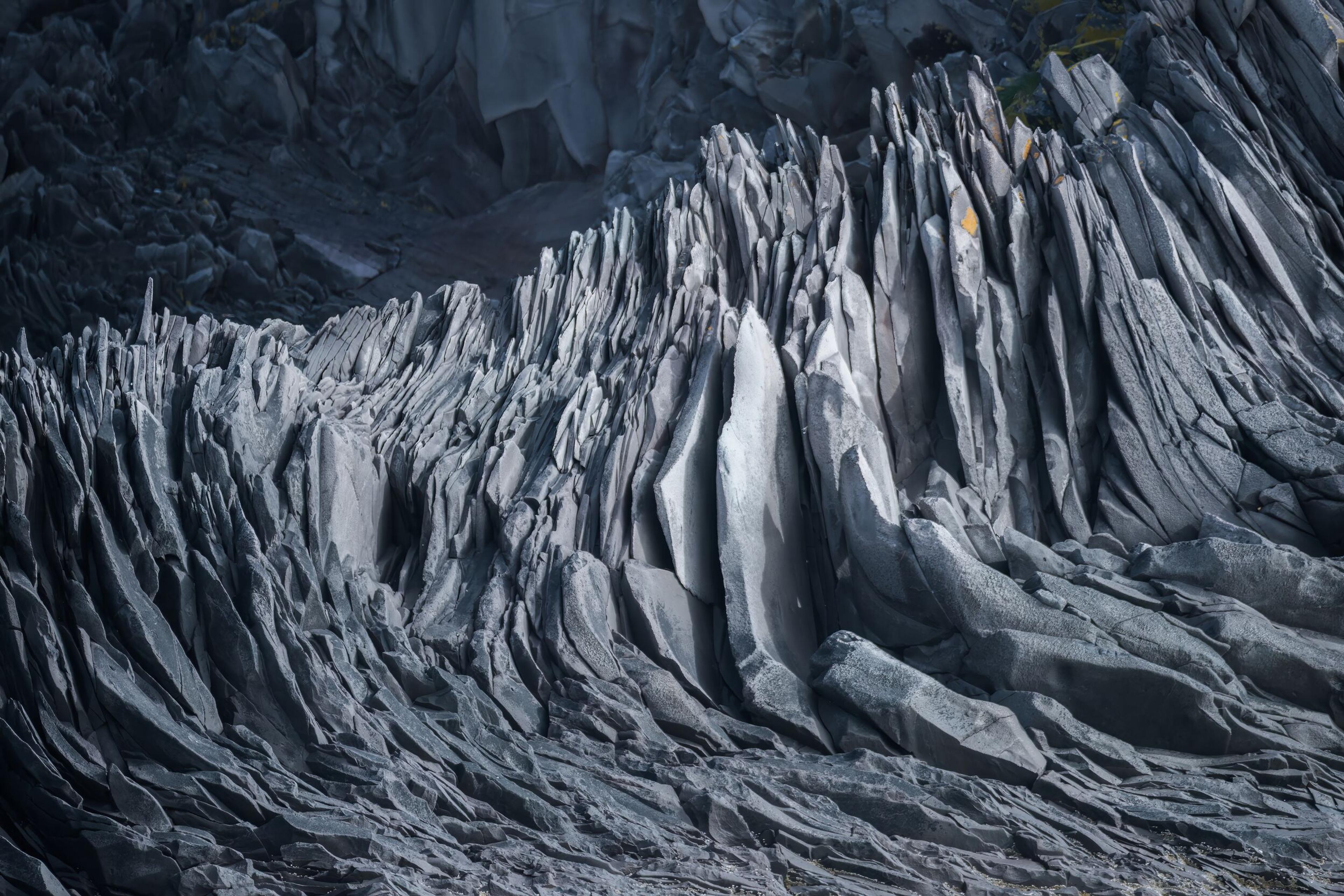 Jagged dark gray rock formations with sharp vertical columns.