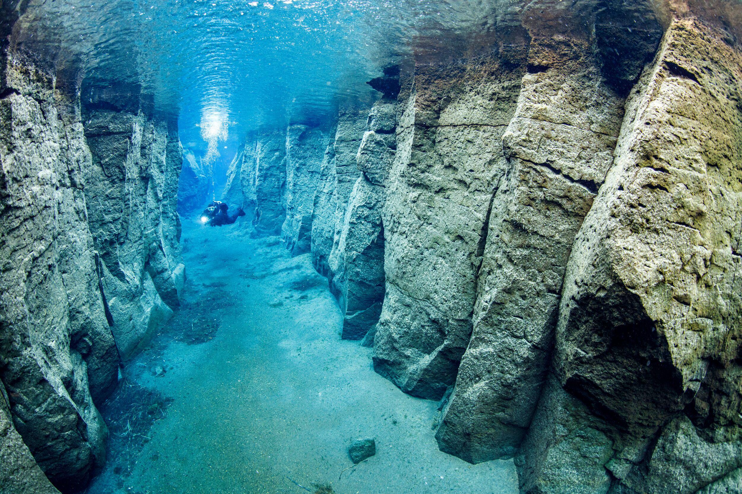 Diver swimming in the Nesgjá fissure river