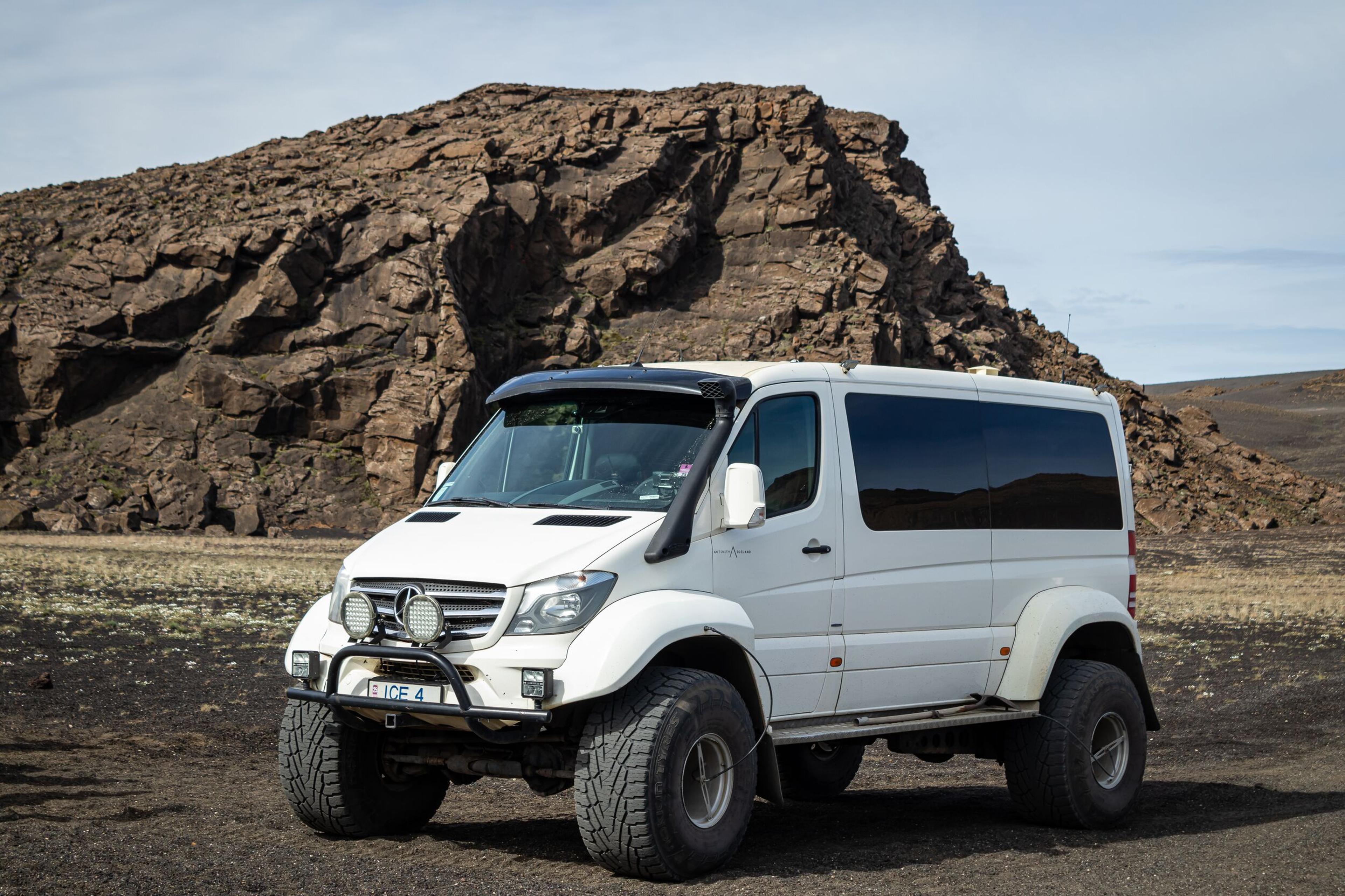 White superjeep parked in the rocky landscape of the Iceland Highlands on a Landmannalaugar tour.