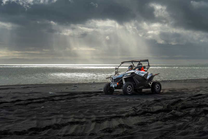 a polaris atv is parked on a sandy beach near the ocean