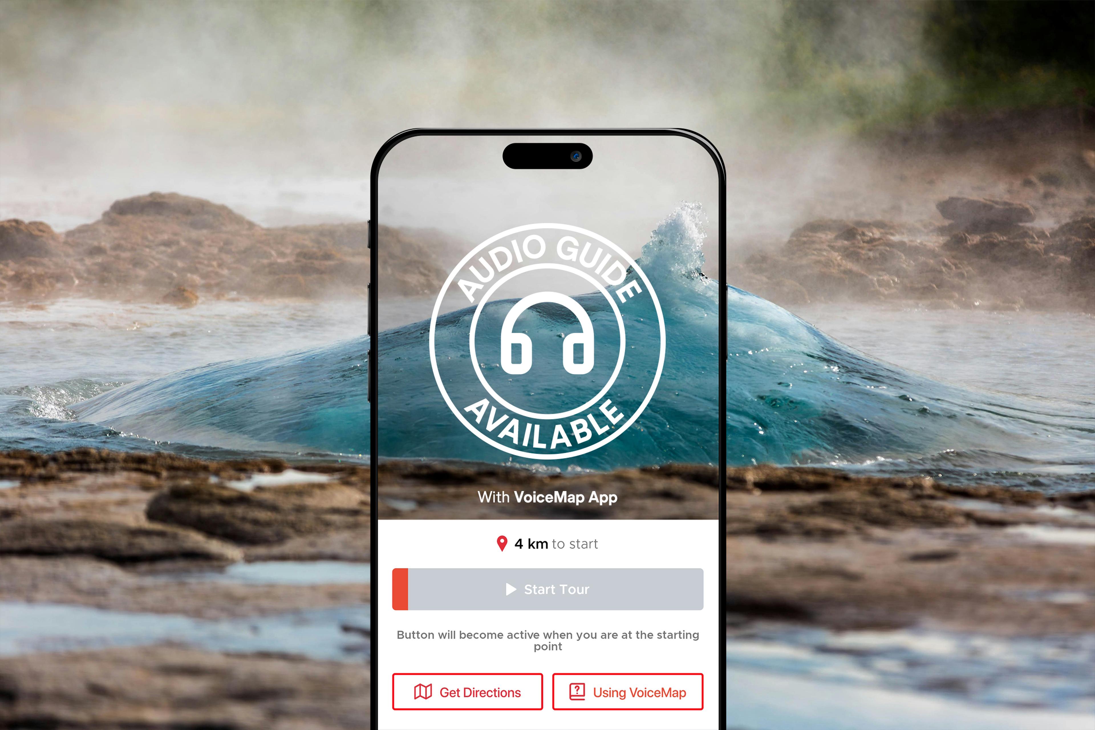 A smartphone screen displaying a VoiceMap app interface is superimposed over a background of a geothermal hot spring, with a circular "Audio Guide Available" icon in the center.