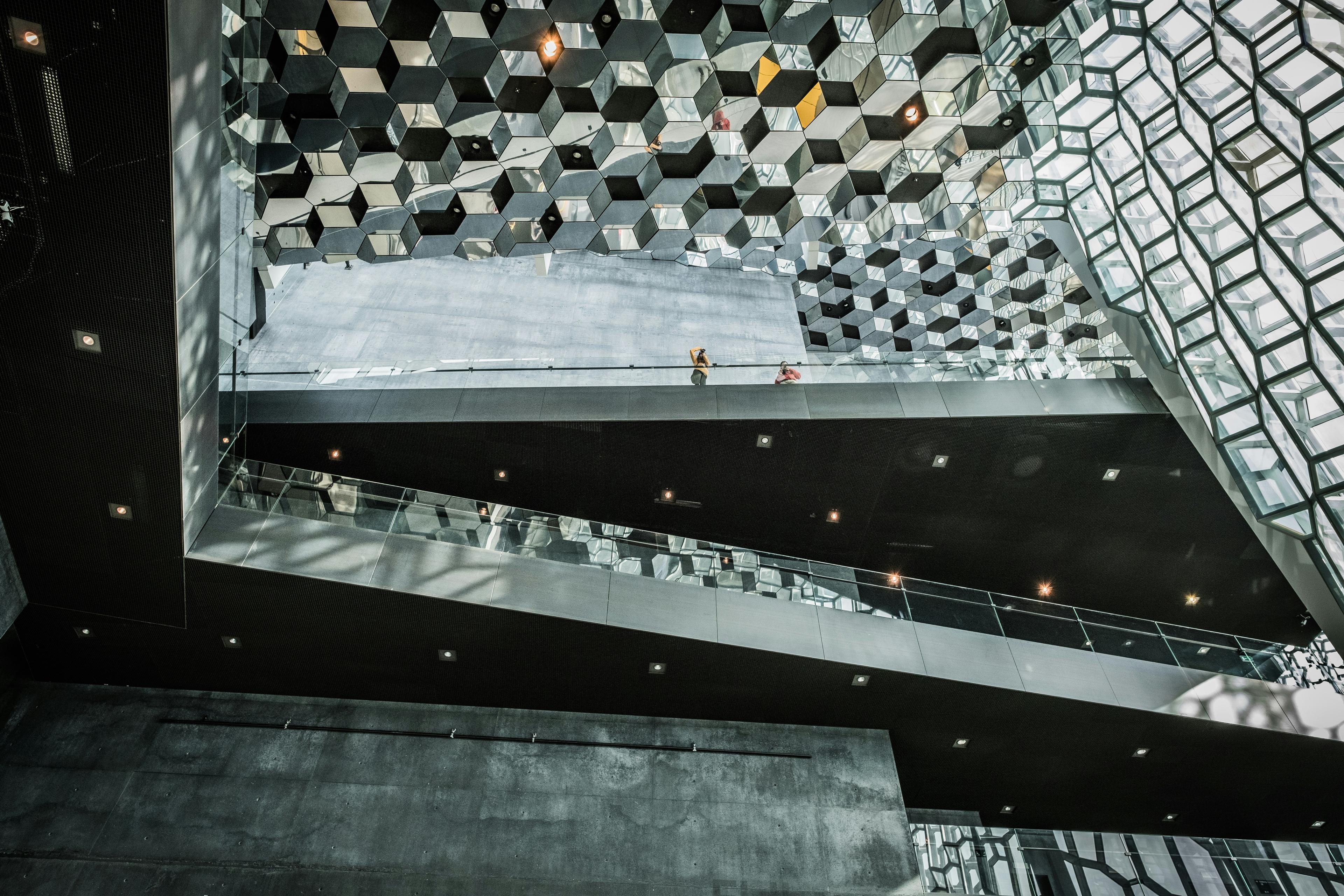 Interior of Harpa Concert Hall showcasing its geometric honeycomb-like glass ceiling and modern architectural design.