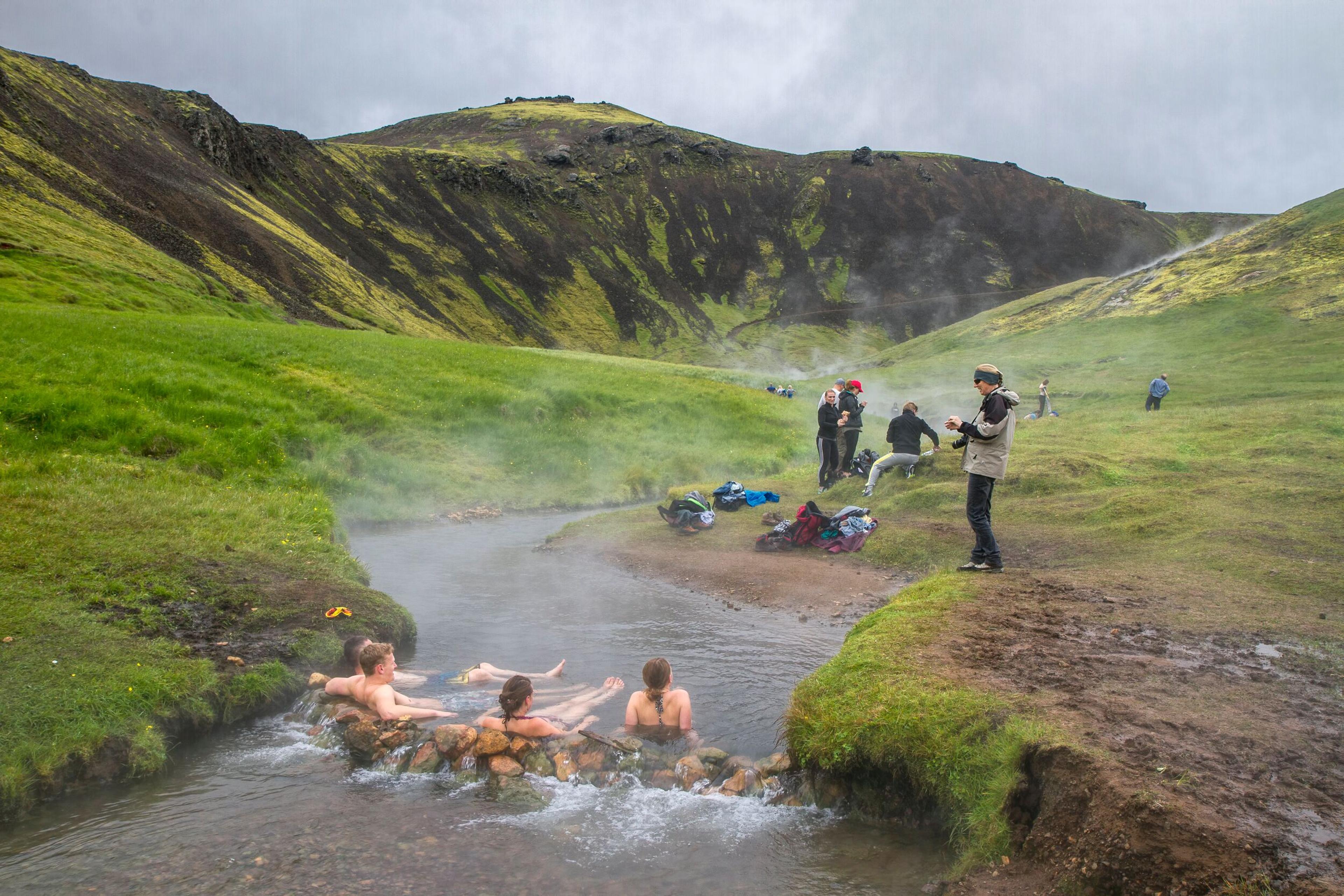 a group of people are taking a bath in a hot spring .