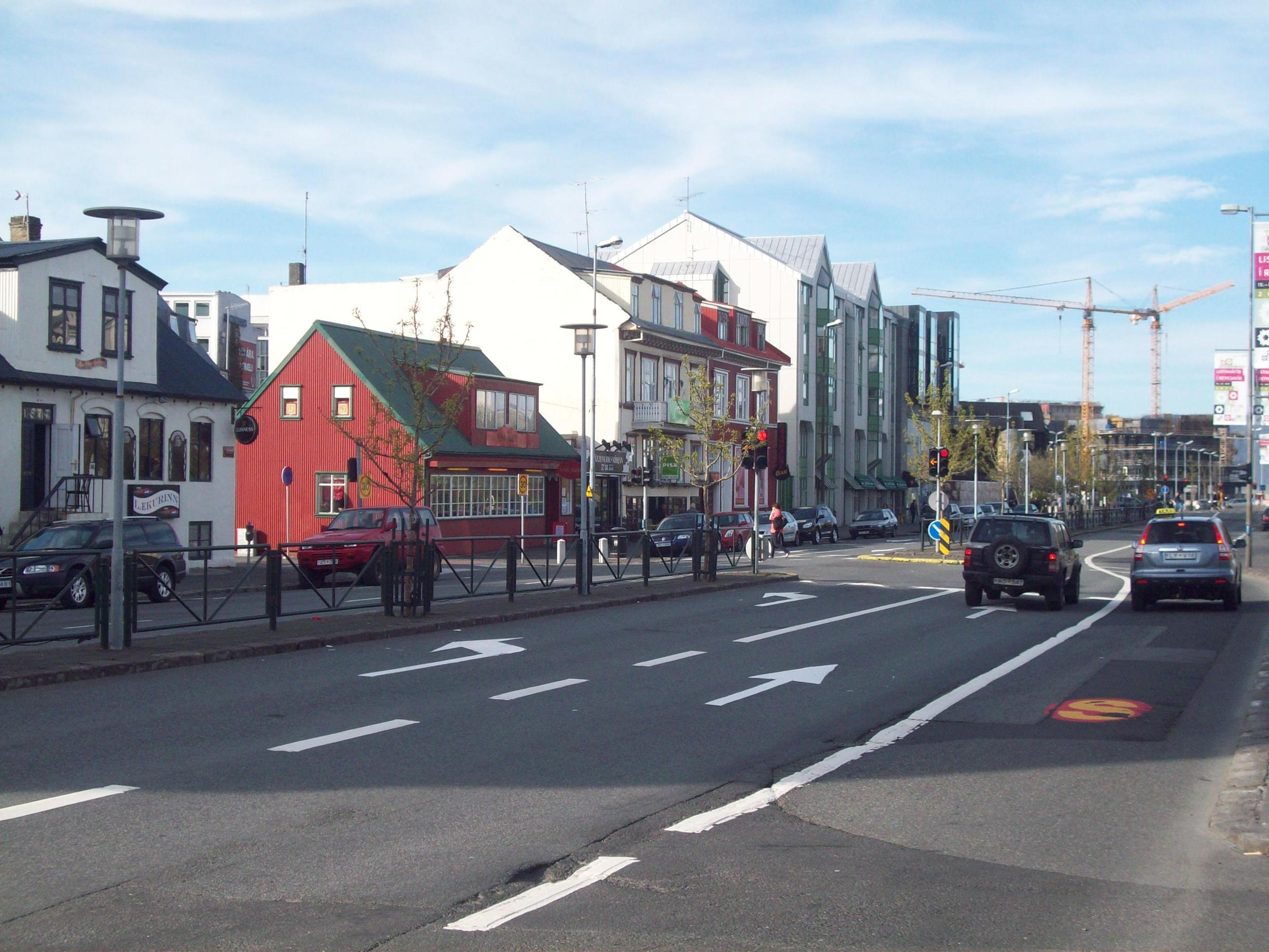 Street view in Reykjavik featuring colorful buildings, cars, and a clear blue sky.