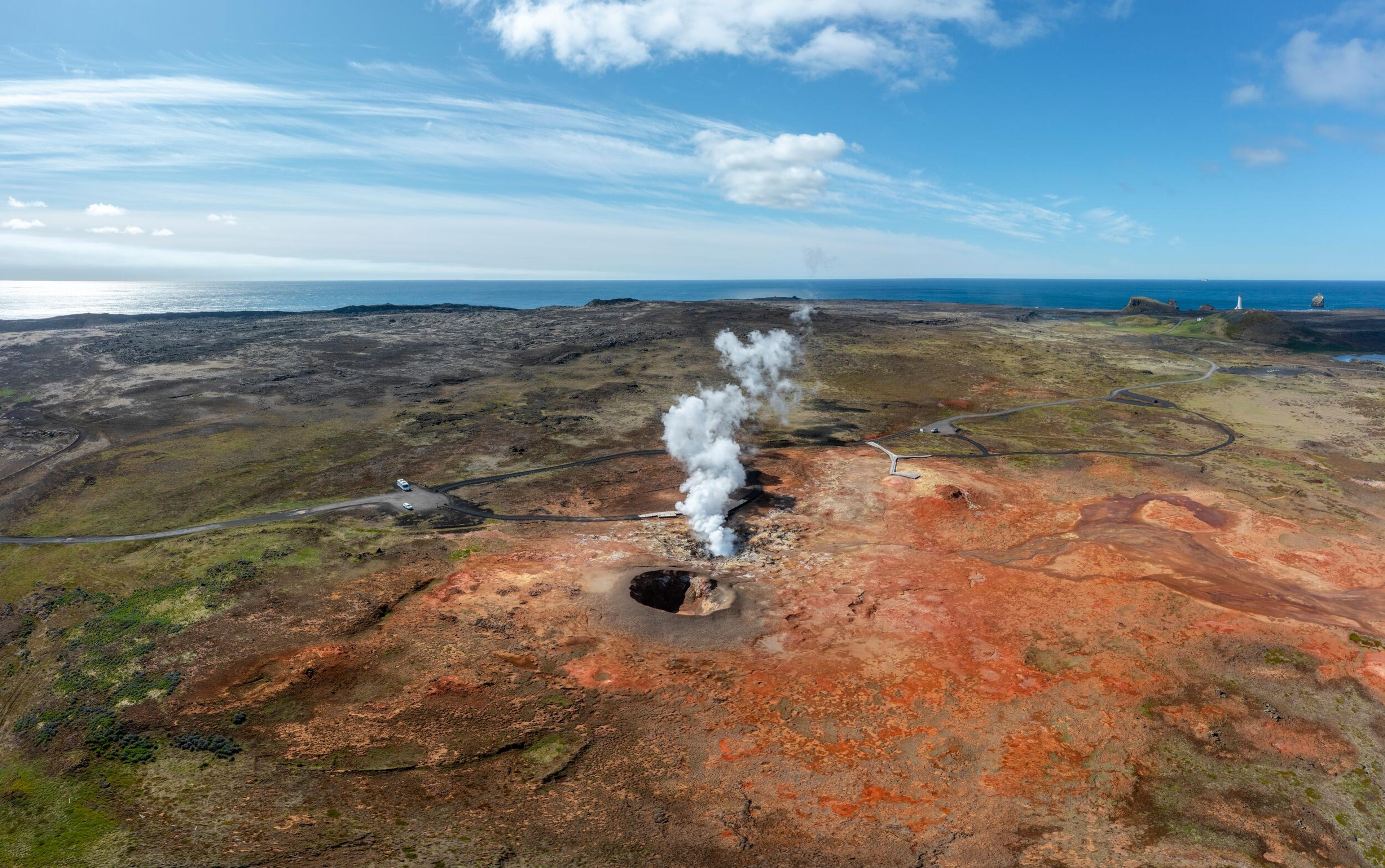 Icelandic volcano with orange lava erupting.