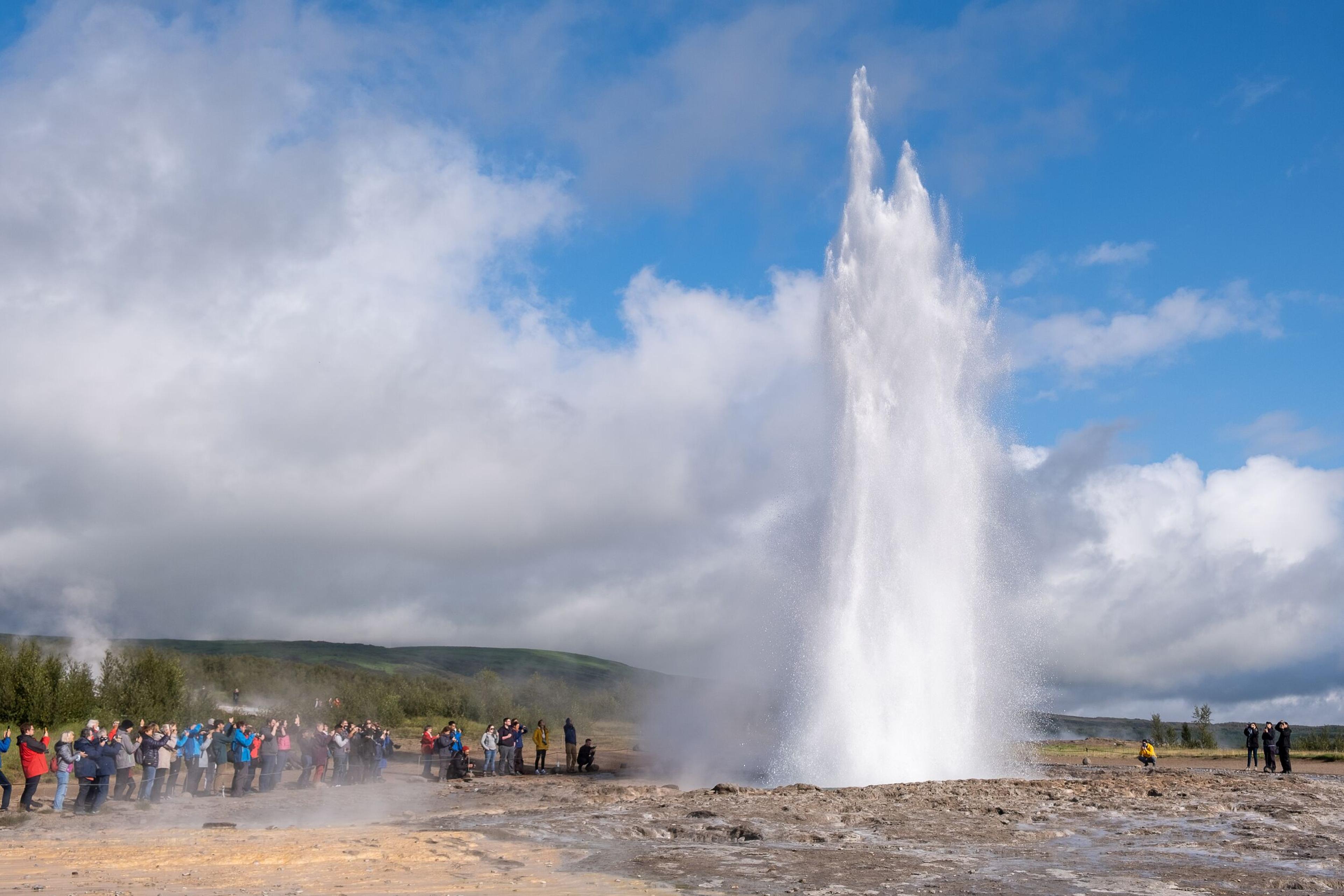 Geysir hotspring erupting in front of tourist in Iceland