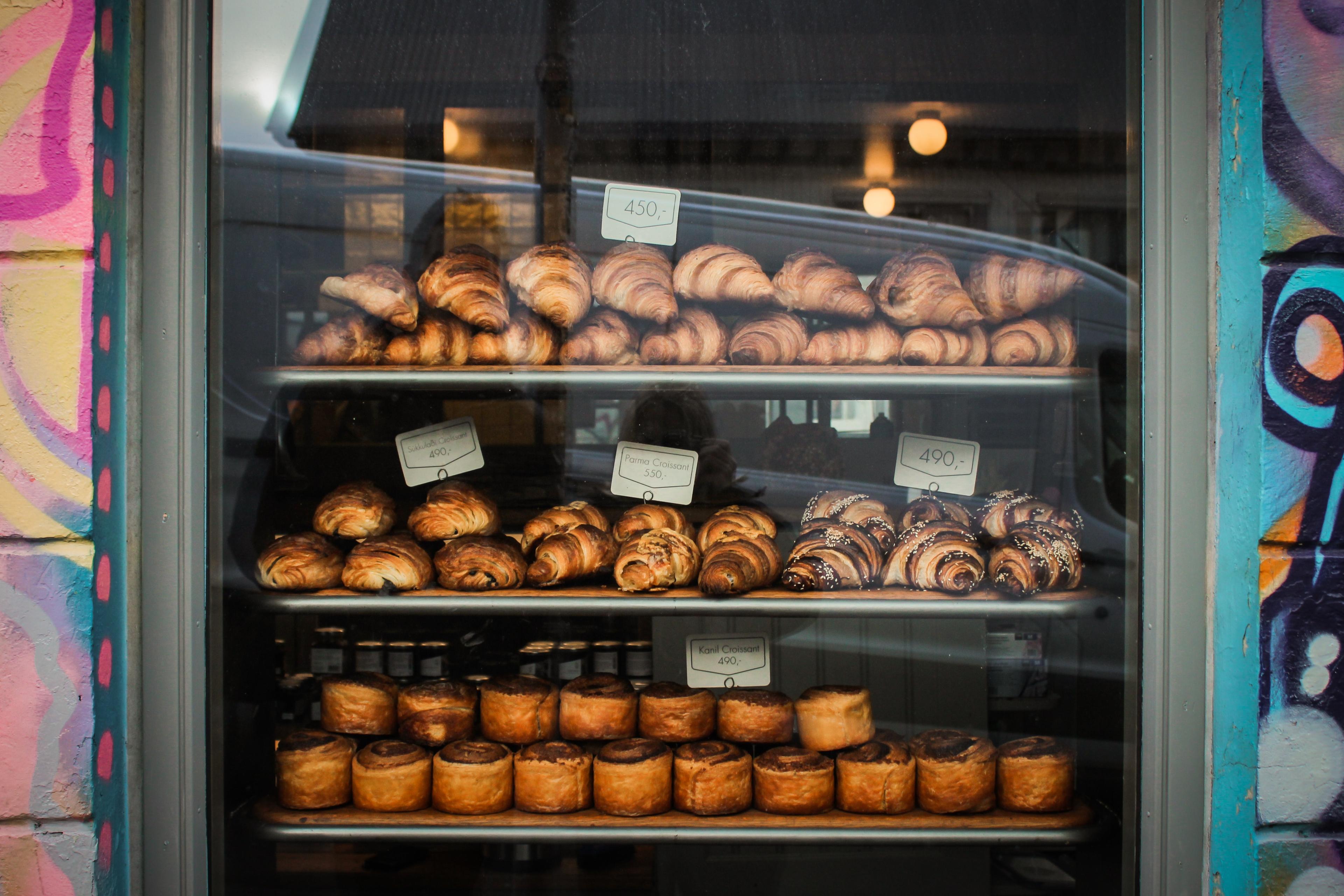 "Assortment of pastries displayed in a store window, set against the backdrop of graffiti-covered walls.