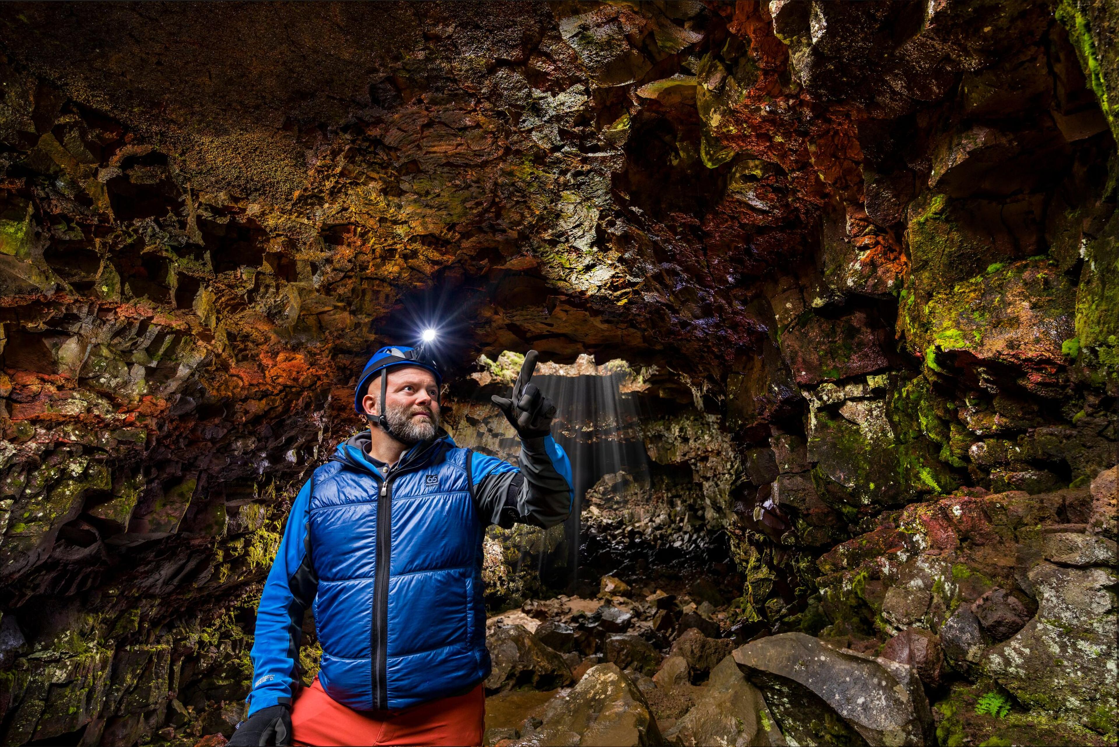 A guide exploring the lava tunnel in Raufarhólshellir, Iceland.