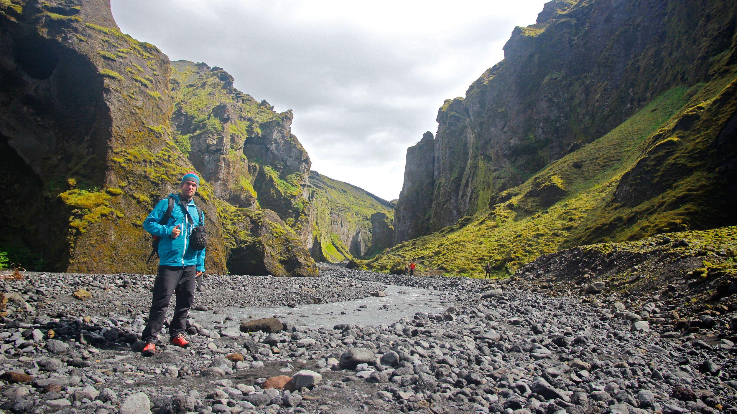 Explorer standing at the bottom of Stakkholtsgjá Canyon in Iceland