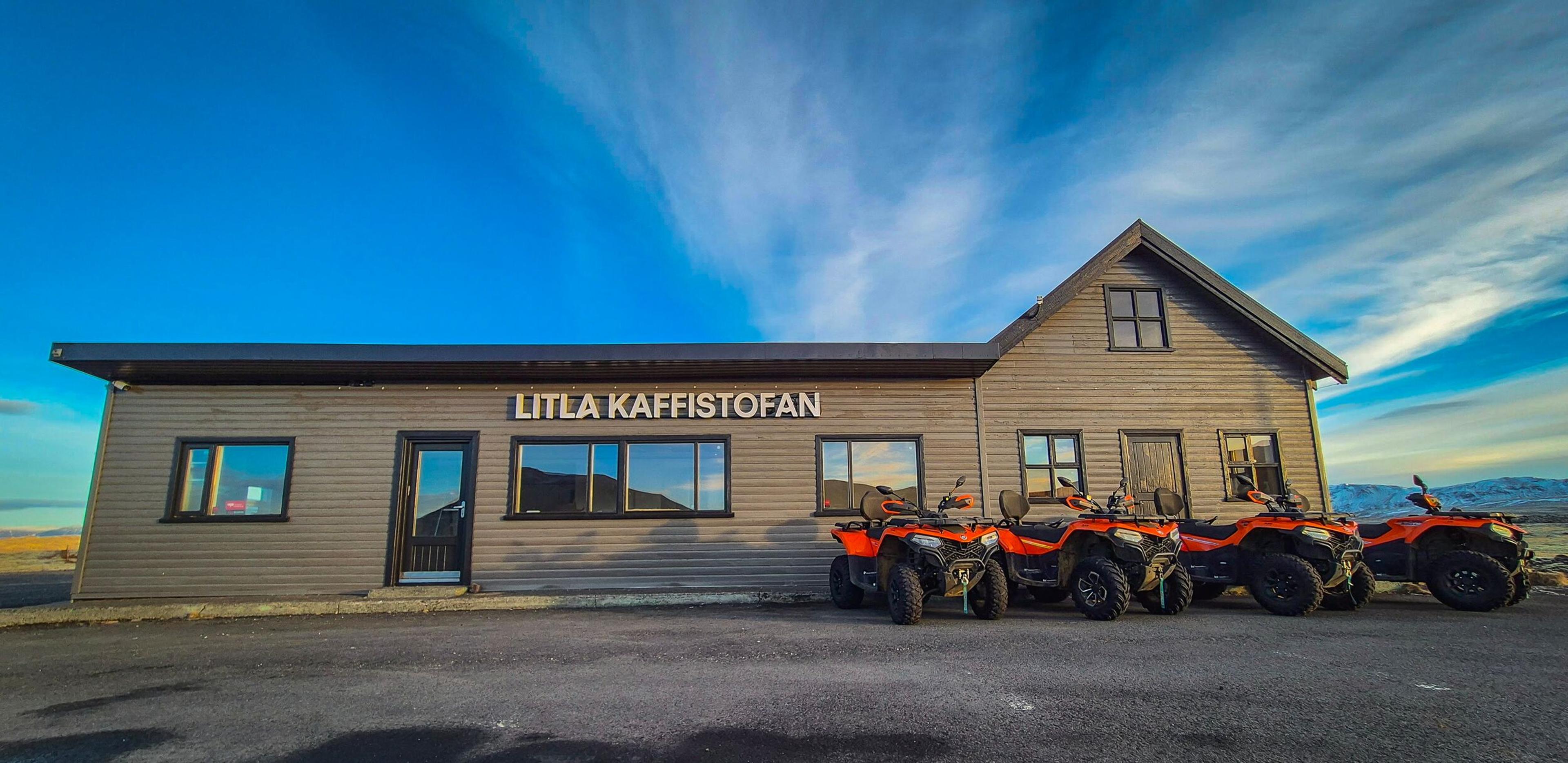 Grey building with "LITLA KAFFISTOFAN" sign and four orange ATVs parked outside.