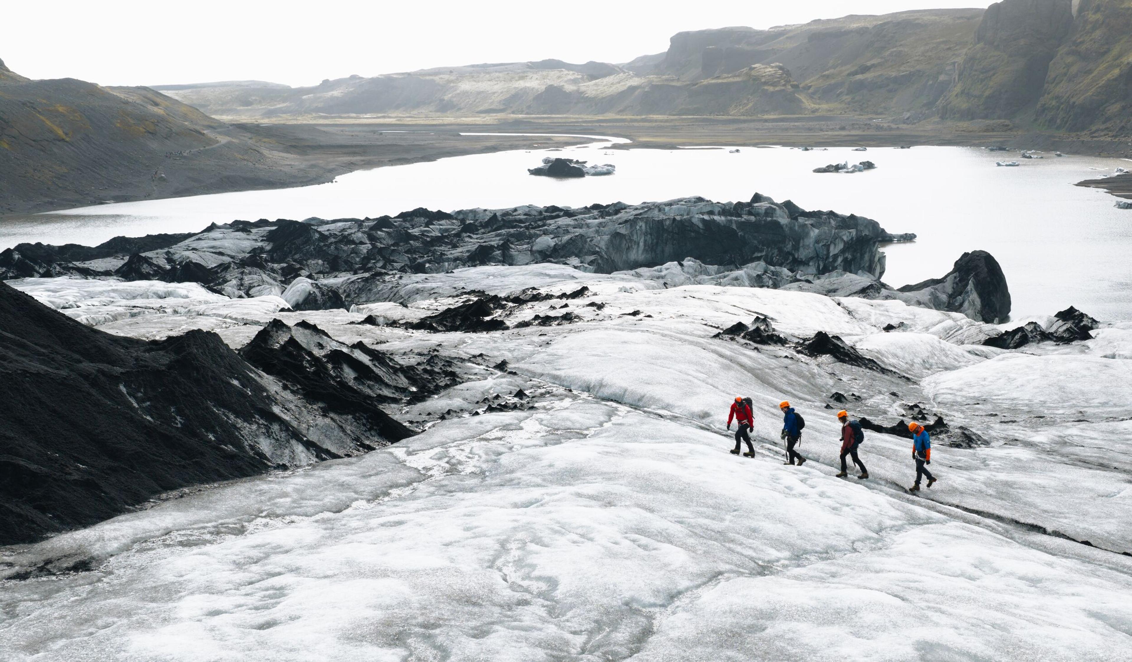 a group of people are walking on top of a glacier