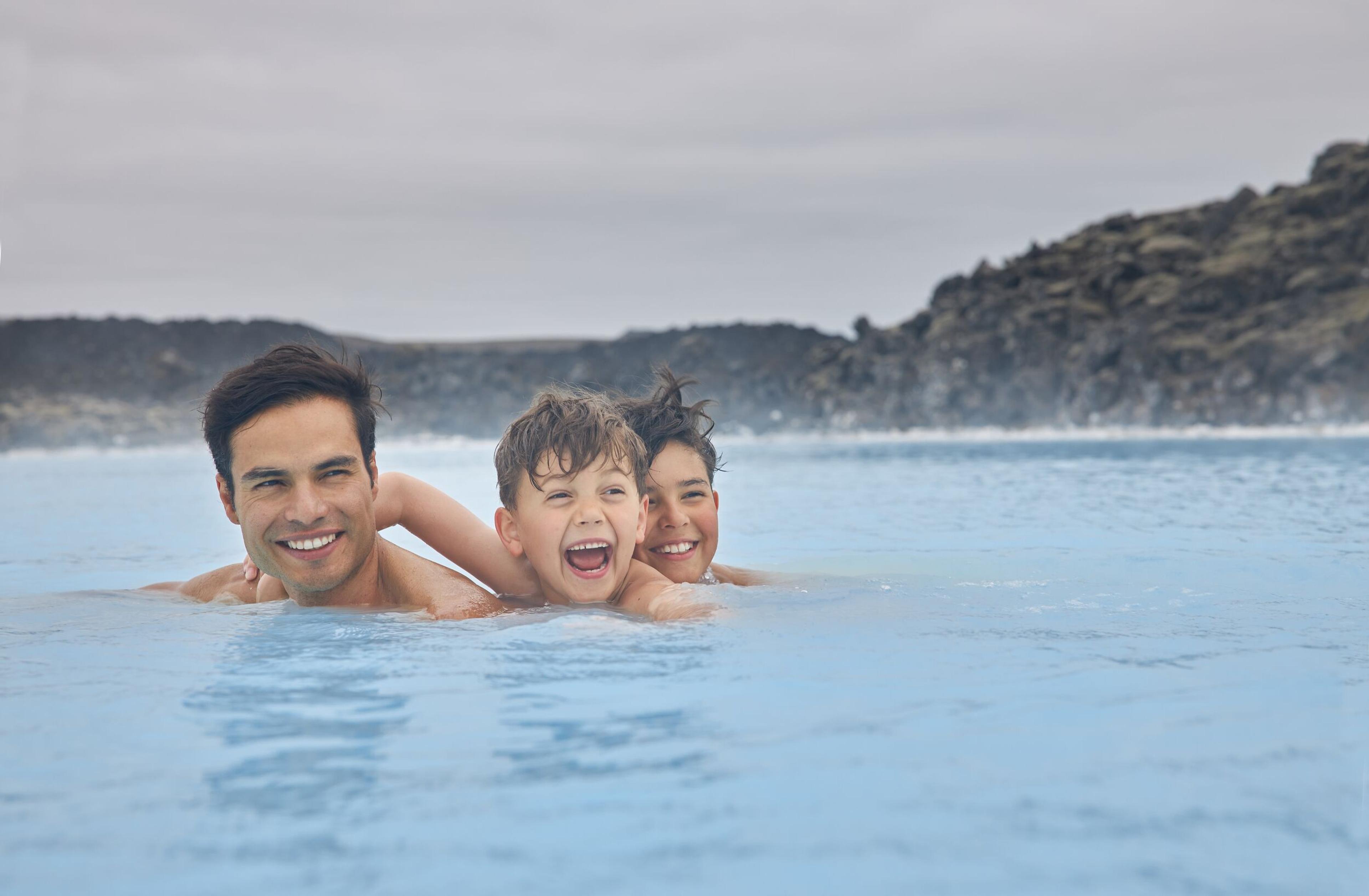 A man and two children enjoying the silica water in Blue lagoon, Iceland