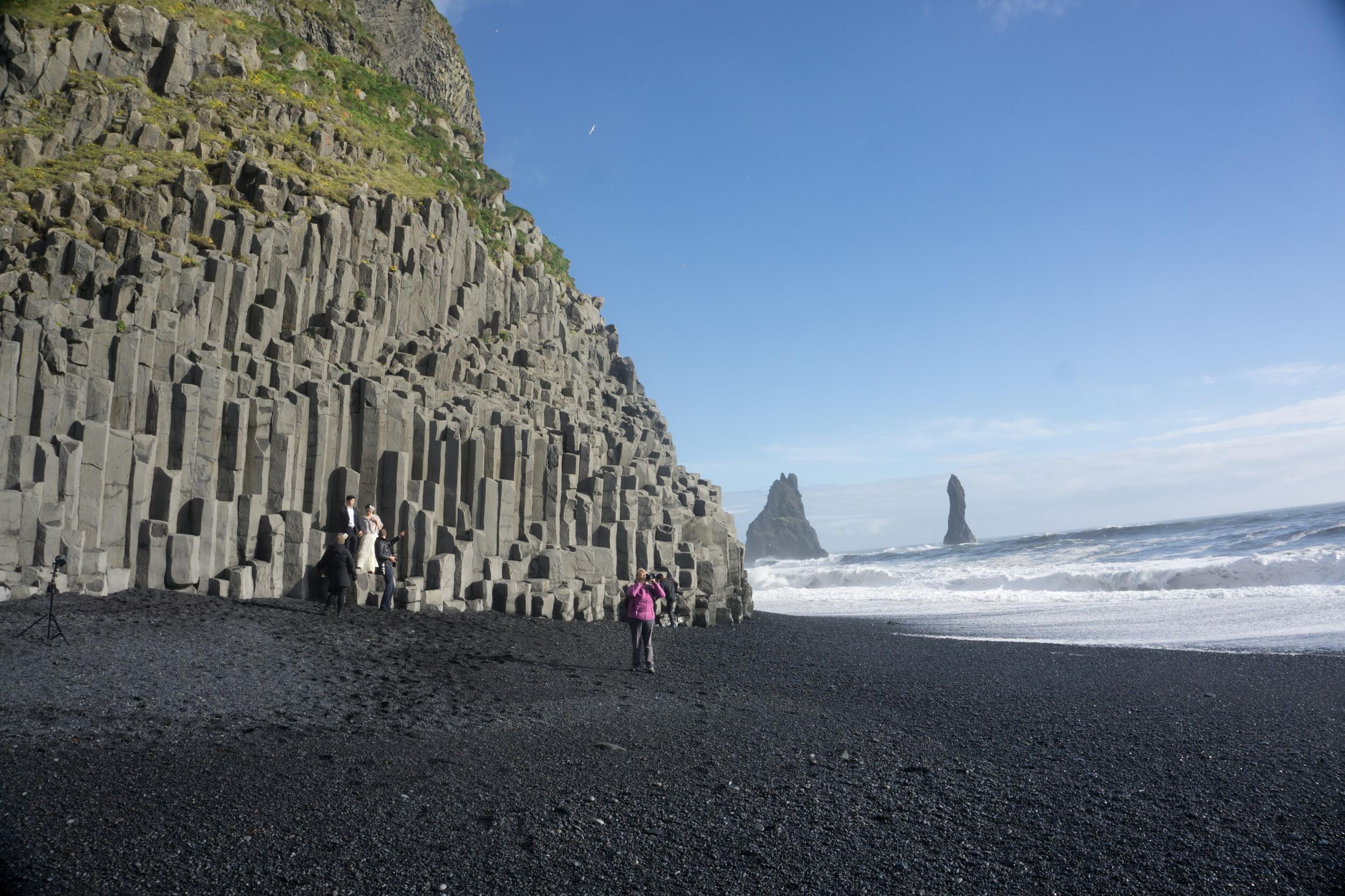 A person walking on the black beach of Reynisfjara in the south coast of Iceland.