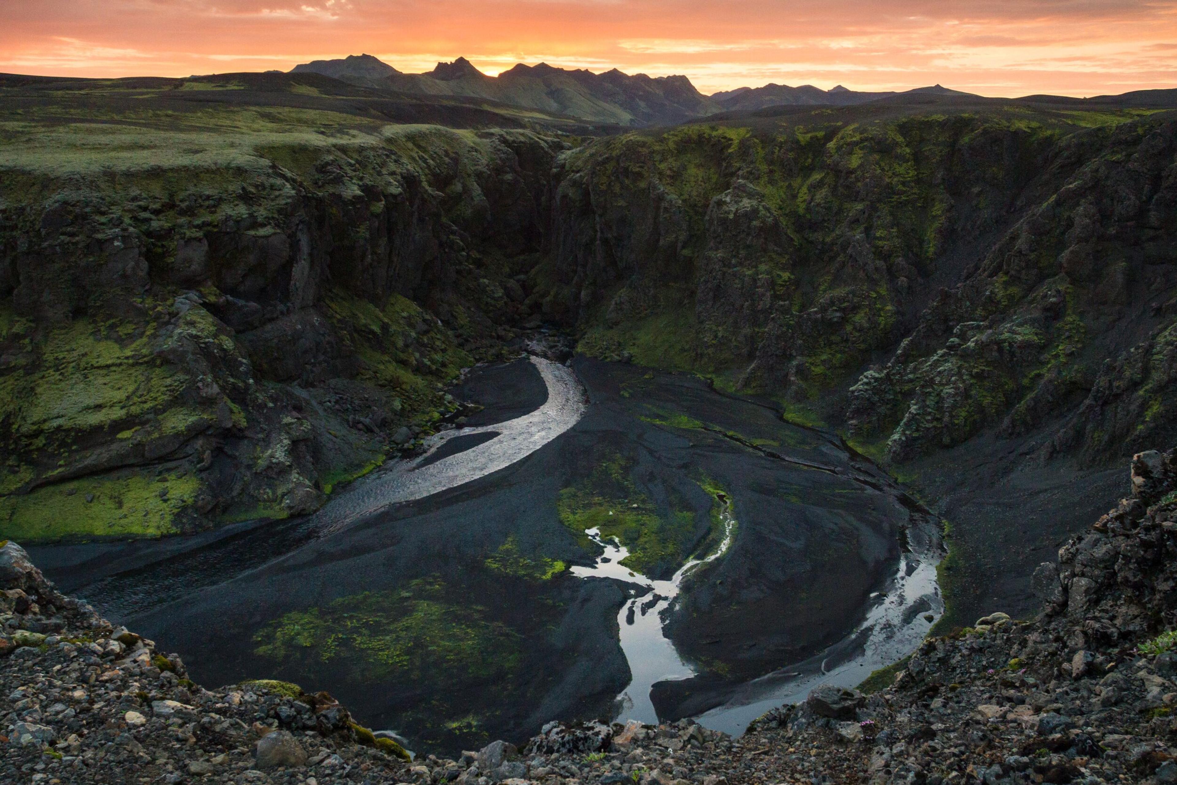 Sunset at Hvanngil: Serene Green Landscape Meets Black Sand and River's Flow